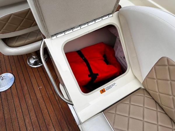 Storage compartment on a 2014 Chris-Craft 28 LAUNCH boat with a red life jacket.