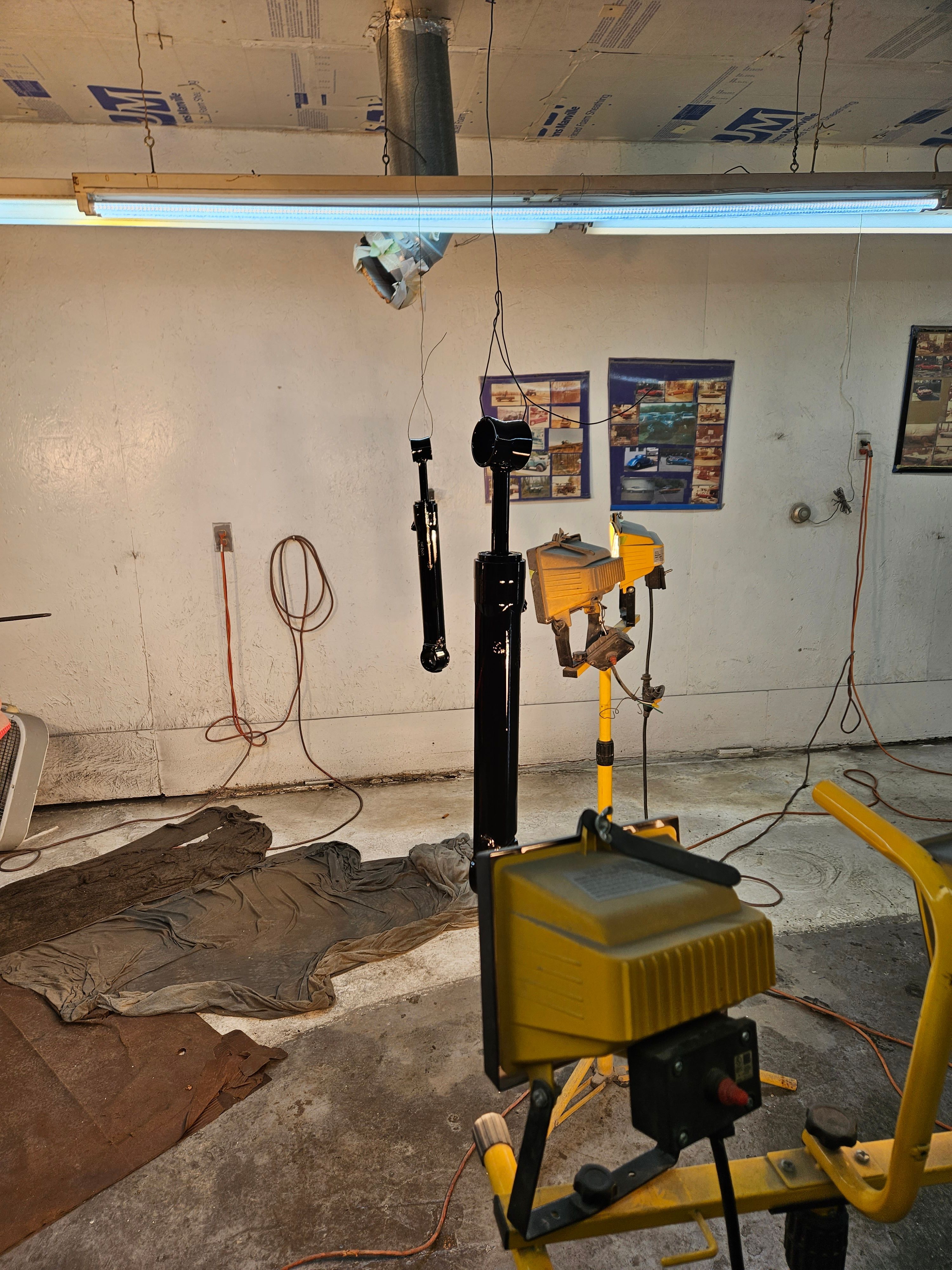 A workshop with hanging painted parts and tools.