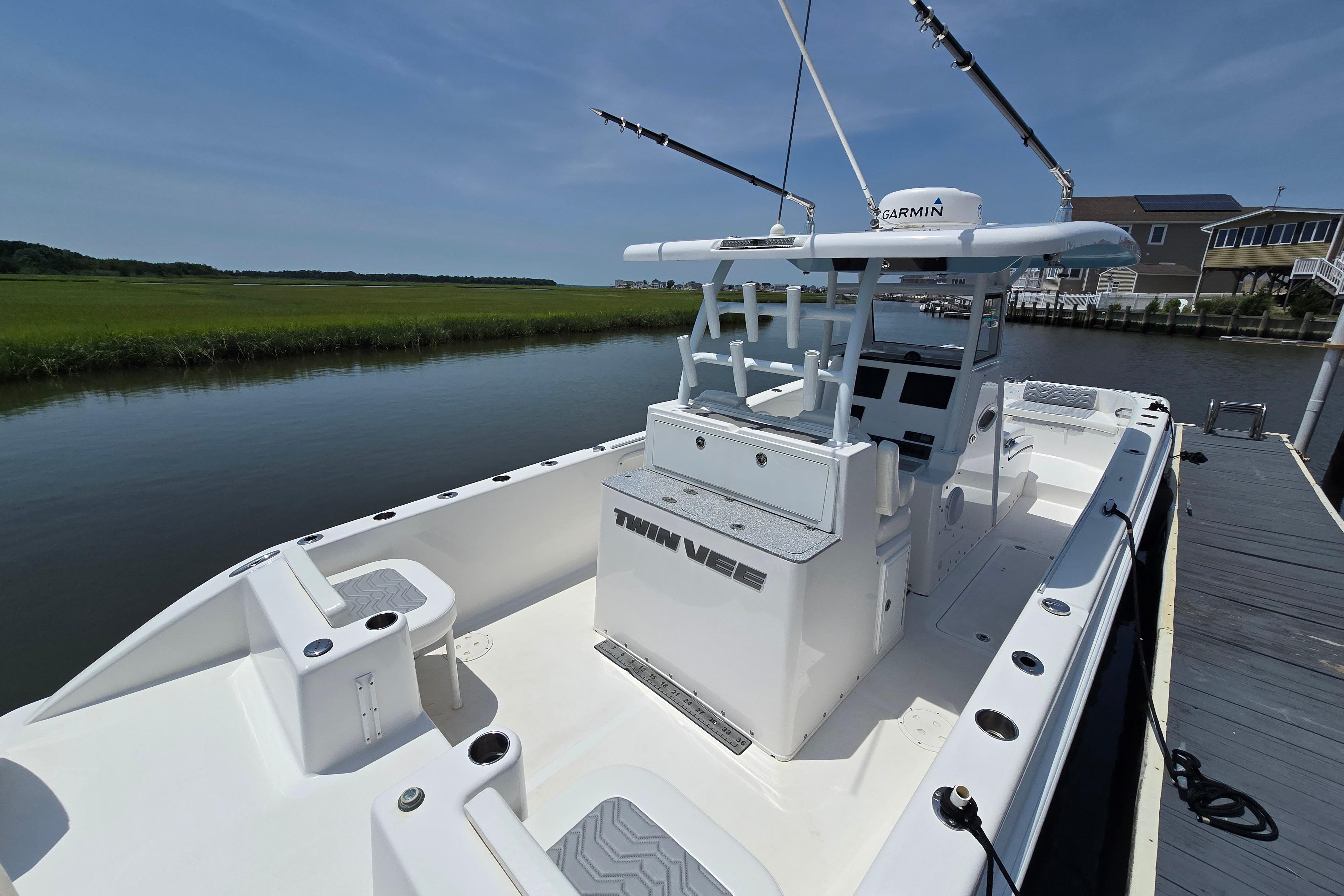 2021 Twin Vee 280 GFX CC boat docked by a serene waterway.