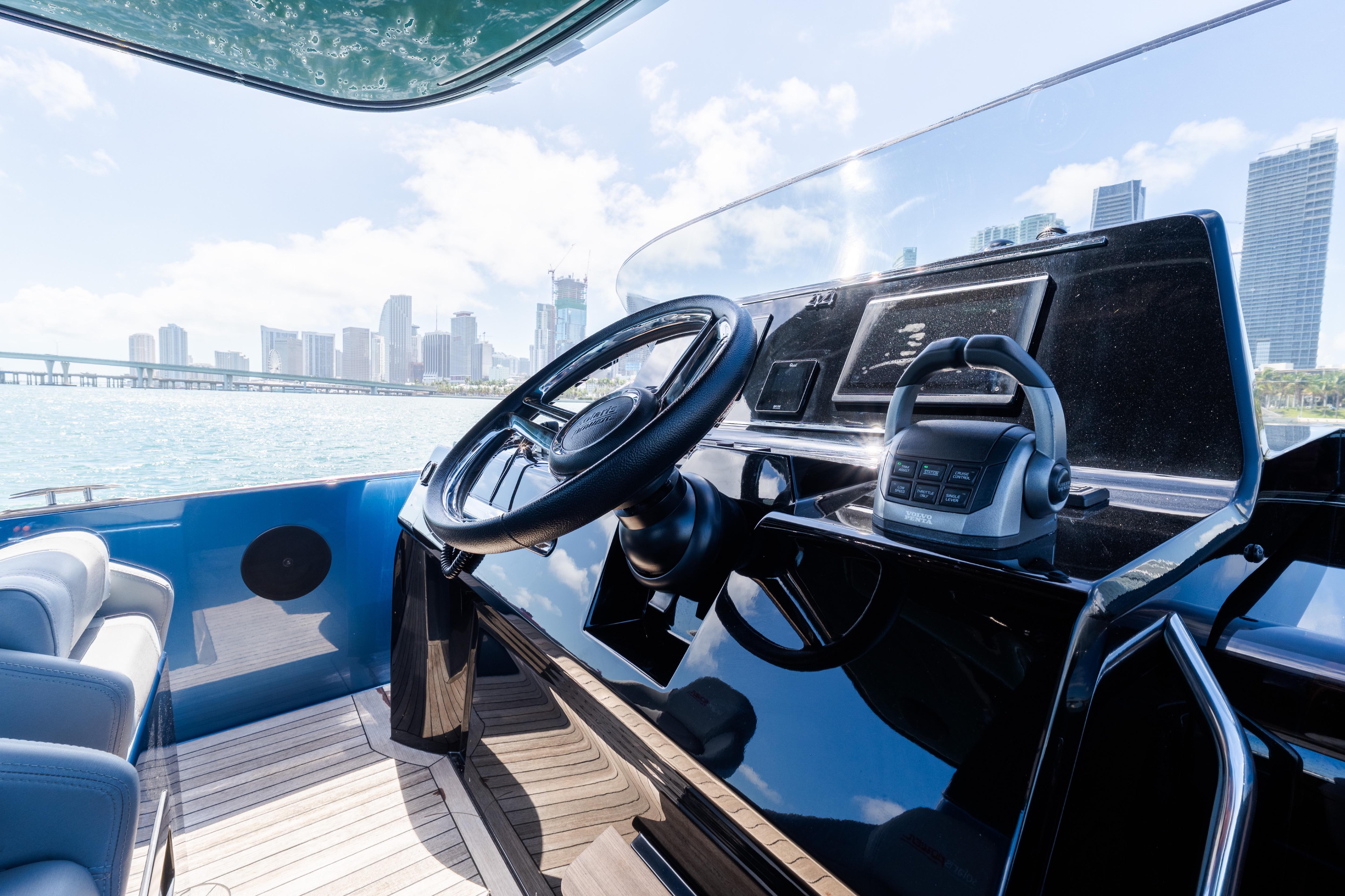 Helm of 2023 Solaris Power 44 Open yacht with city skyline view.