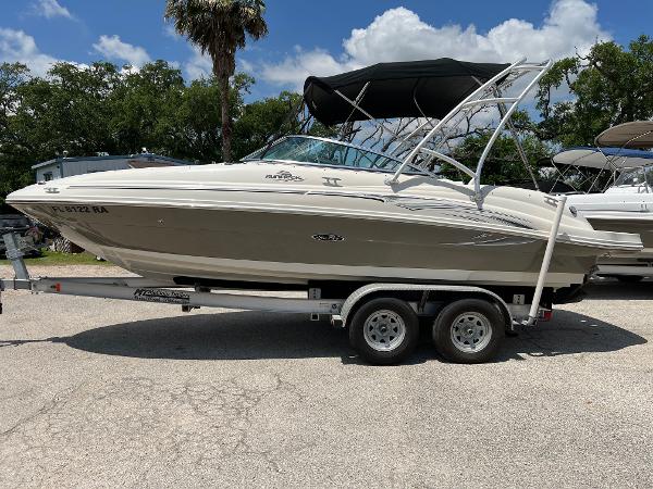 2005 Sea Ray 220 Sundeck boat on trailer, parked outdoors under a sunny sky.