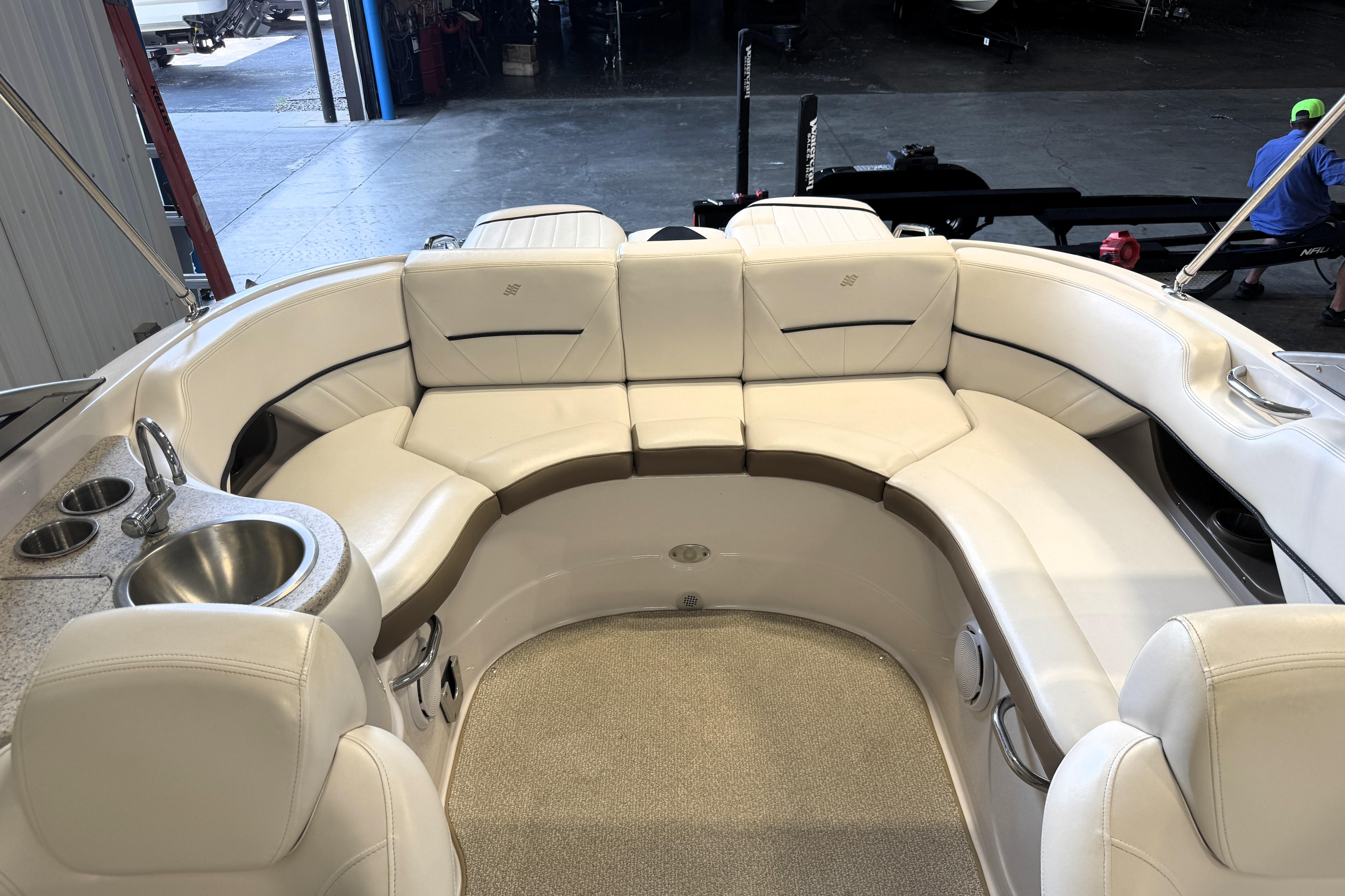 Interior of 2008 Four Winns H240 boat with white seating and built-in sink.
