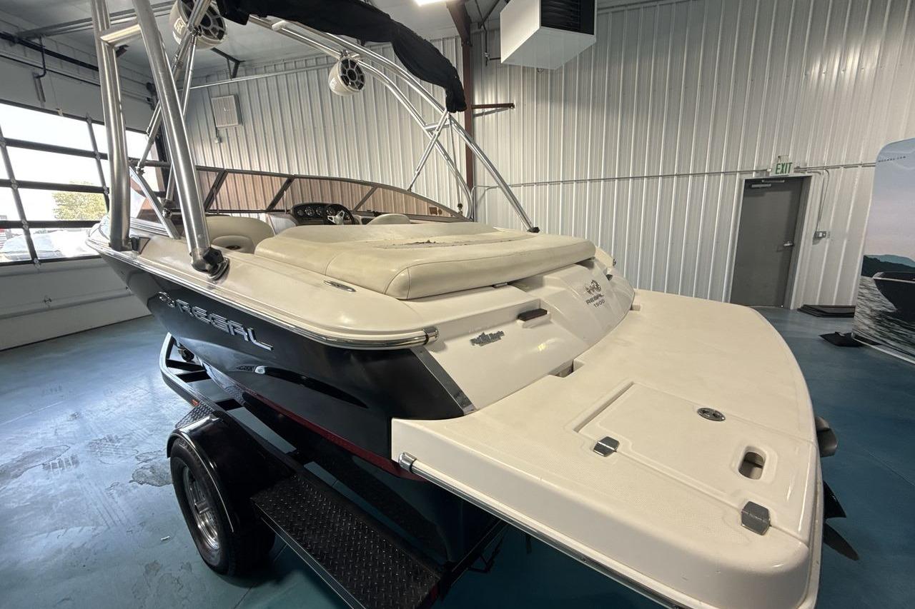 2012 Regal 1900 Bowrider boat in indoor showroom, featuring sleek design and spacious seating.