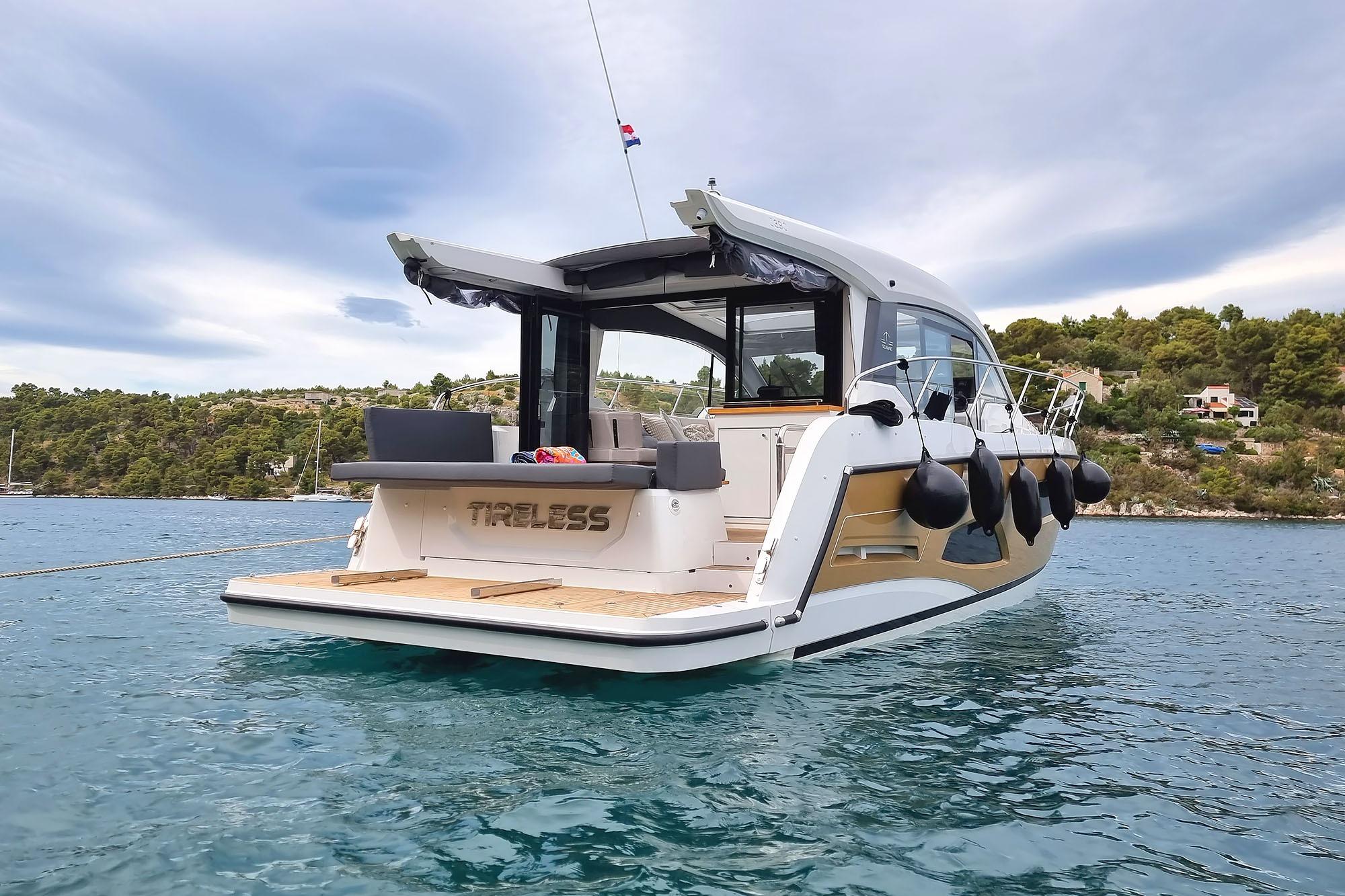 2024 Sealine C390 yacht on water, rear view with open deck and scenic background.