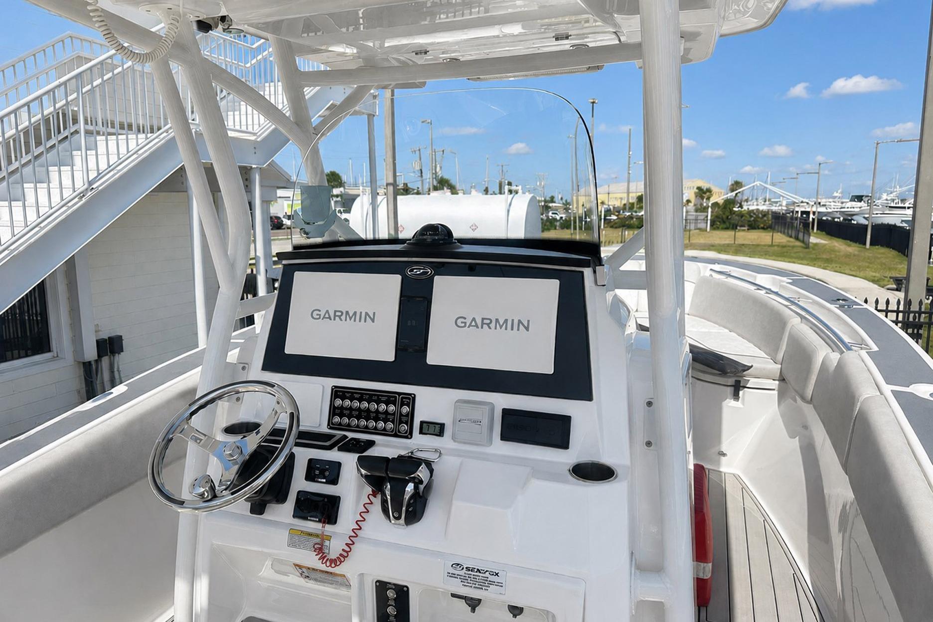 2002 Sea Fox 228 Commander boat dashboard with Garmin navigation systems and steering wheel.