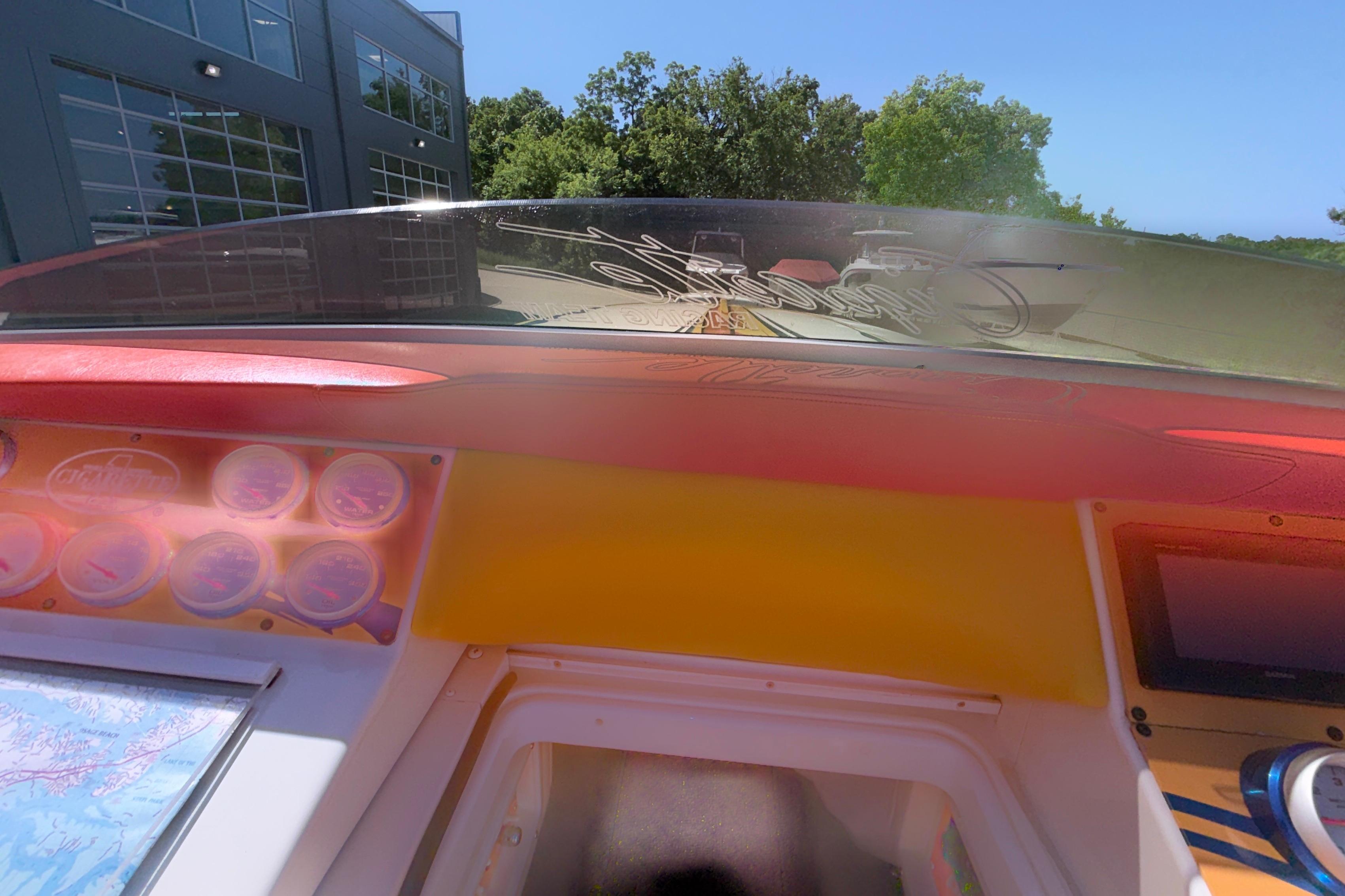 Interior view of a 2002 Cigarette 35' Cafe Racer boat dashboard with gauges and windshield.