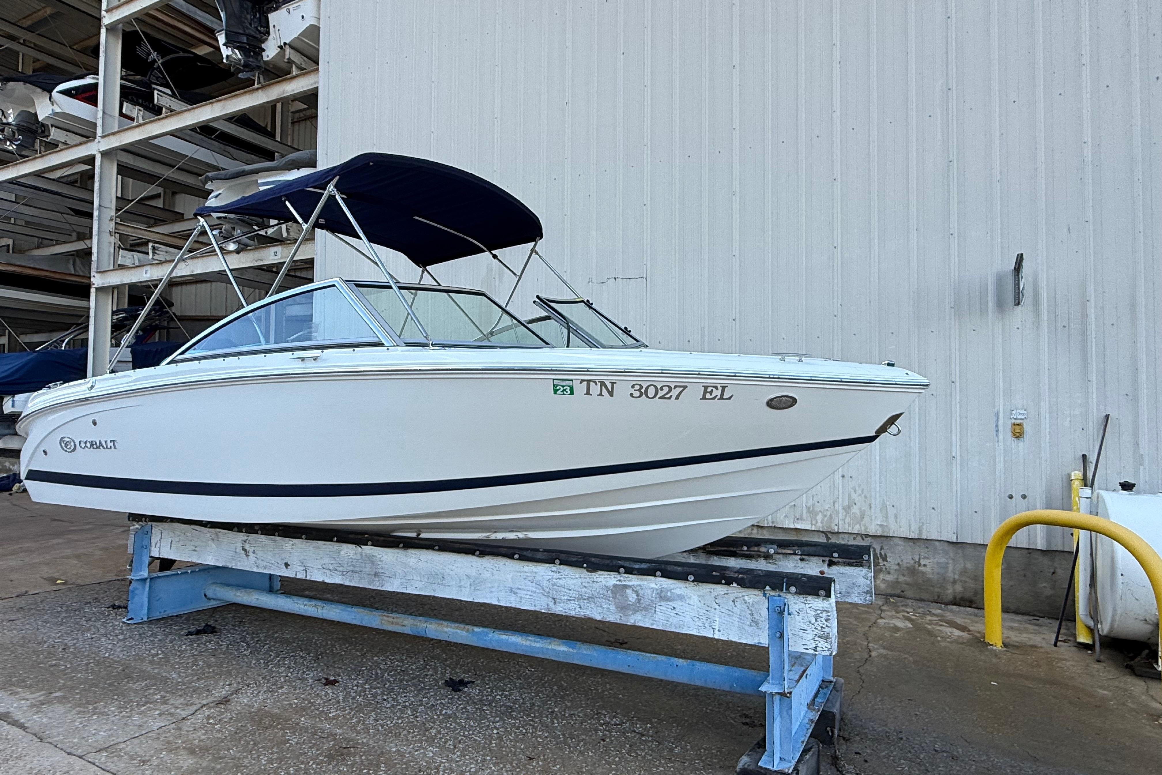 2015 Cobalt 200 boat with blue canopy on a dockside lift.
