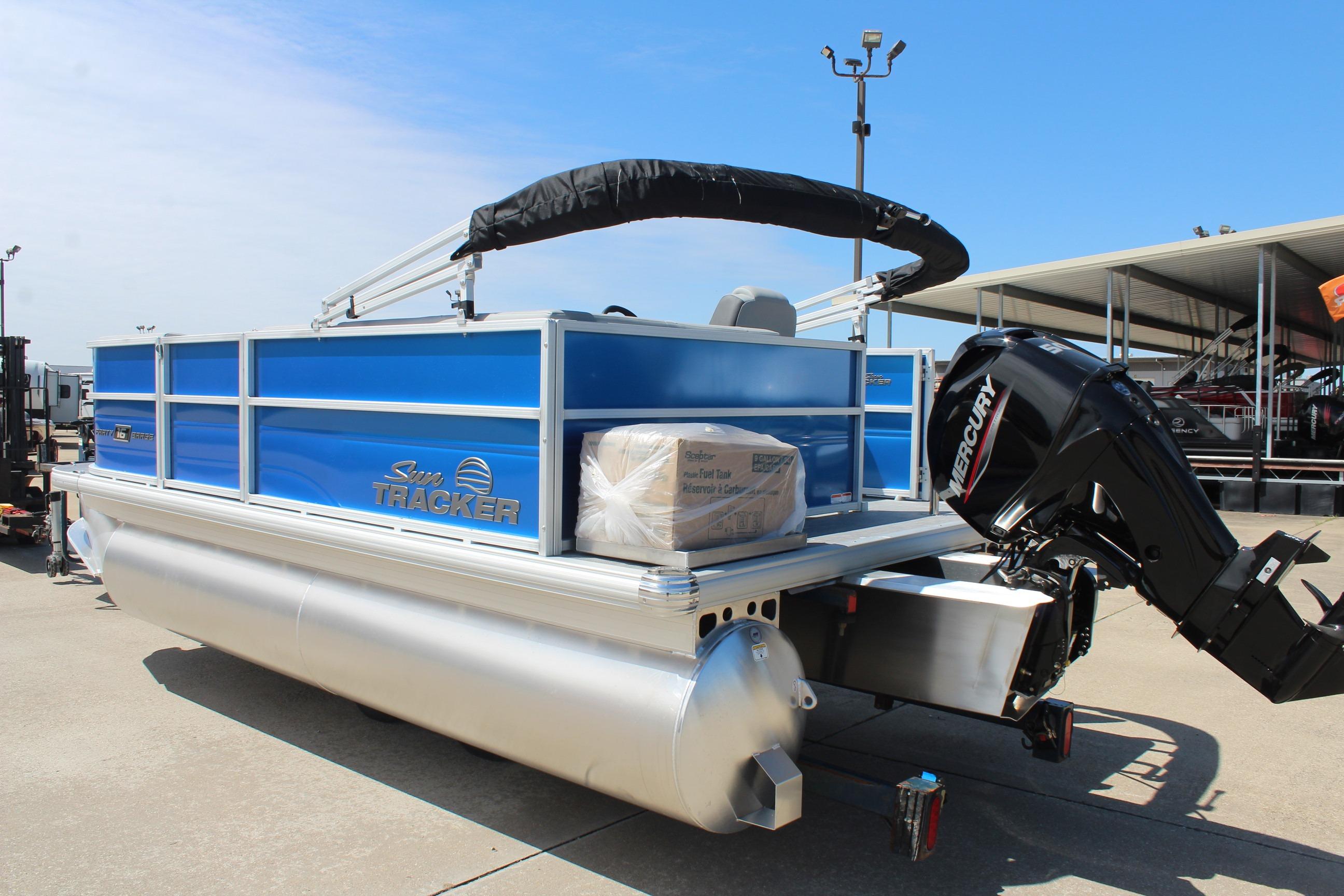 2026 Sun Tracker Party Barge 16 DLX pontoon boat with Mercury outboard motor, docked outdoors.