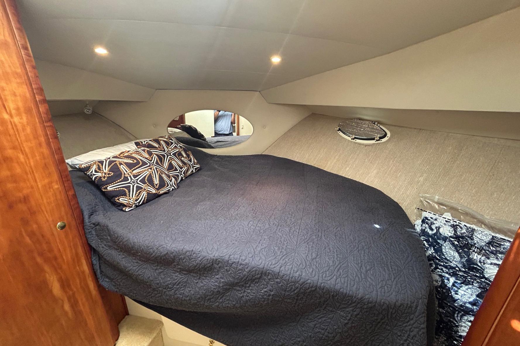 Interior cabin of 2000 Silverton 352 Motor Yacht with cozy bed and decorative pillows.
