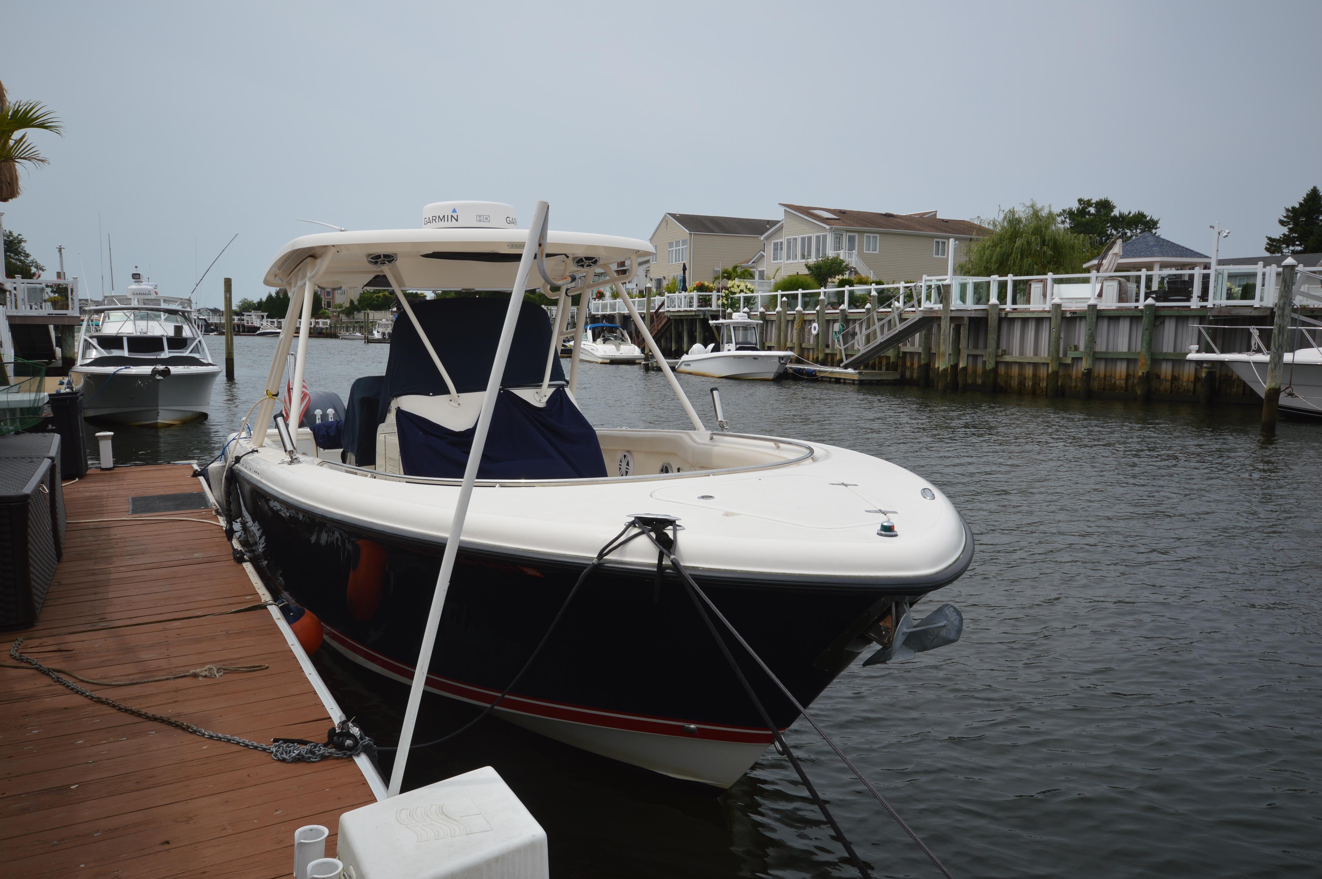 2012 Pursuit 280 boat docked in a residential canal.