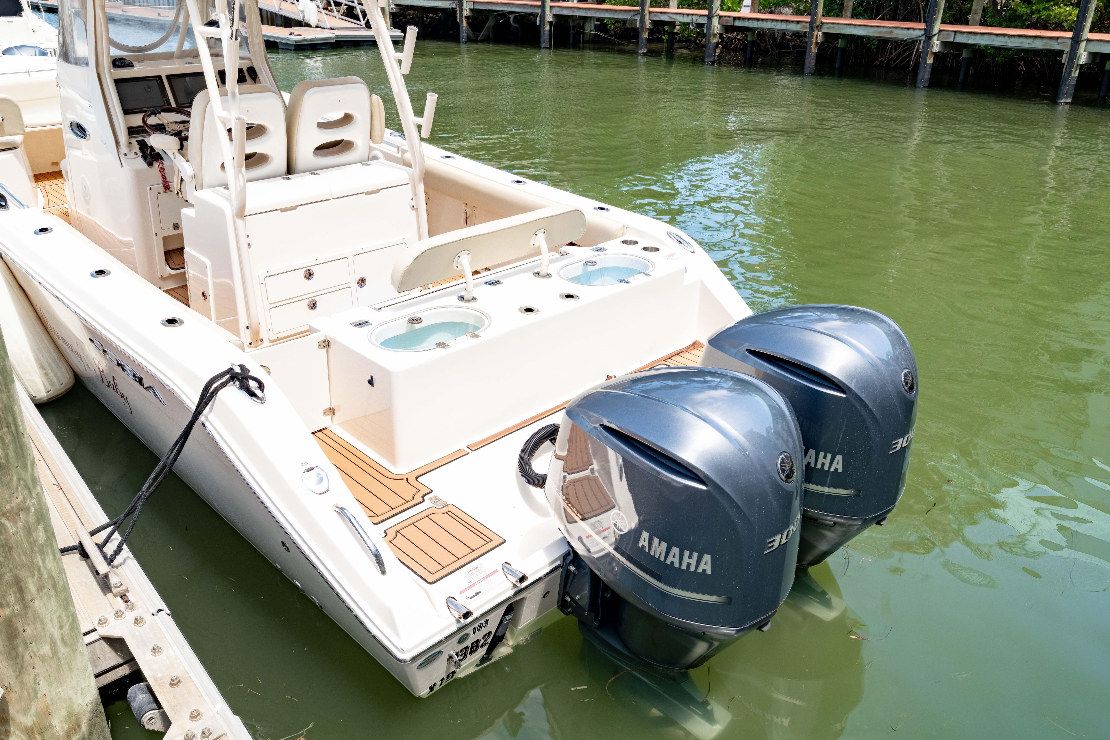 2016 Cobia 296 Center Console boat with twin Yamaha engines docked in marina.