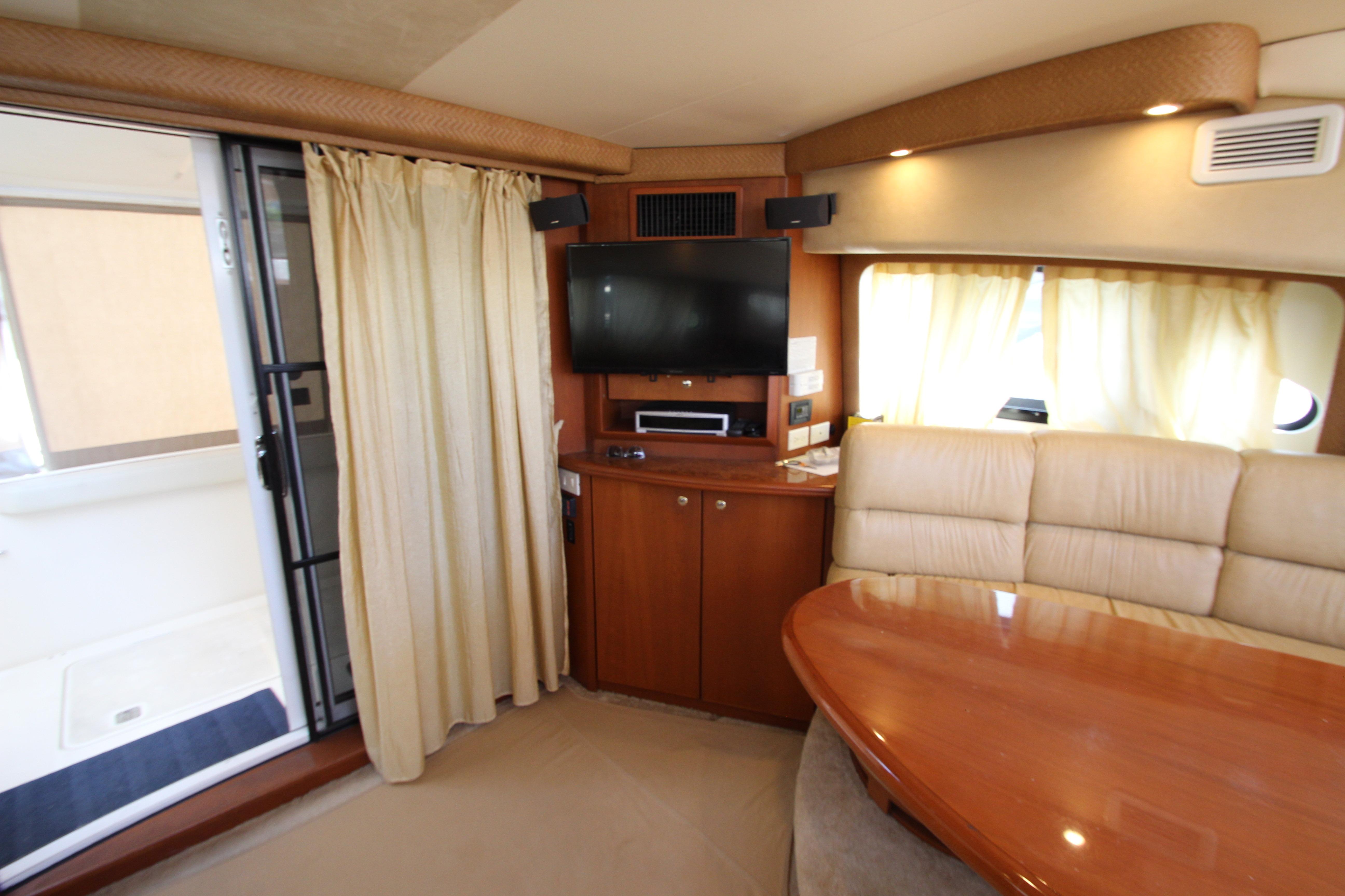 Interior of 2006 Silverton 38 Sport Bridge yacht with TV, seating, and dining area.