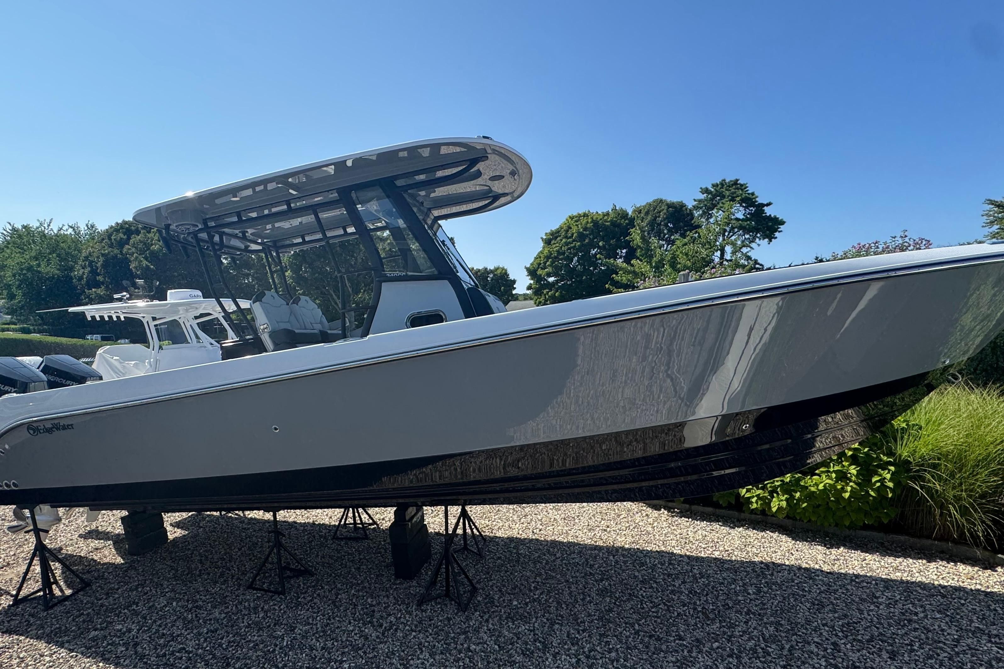 2025 Edgewater 340CC boat on stands, sleek design, sunny day, outdoor setting.