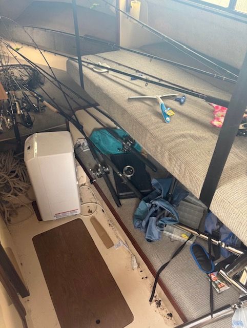 The interior of a boat with fishing rods and gear.
