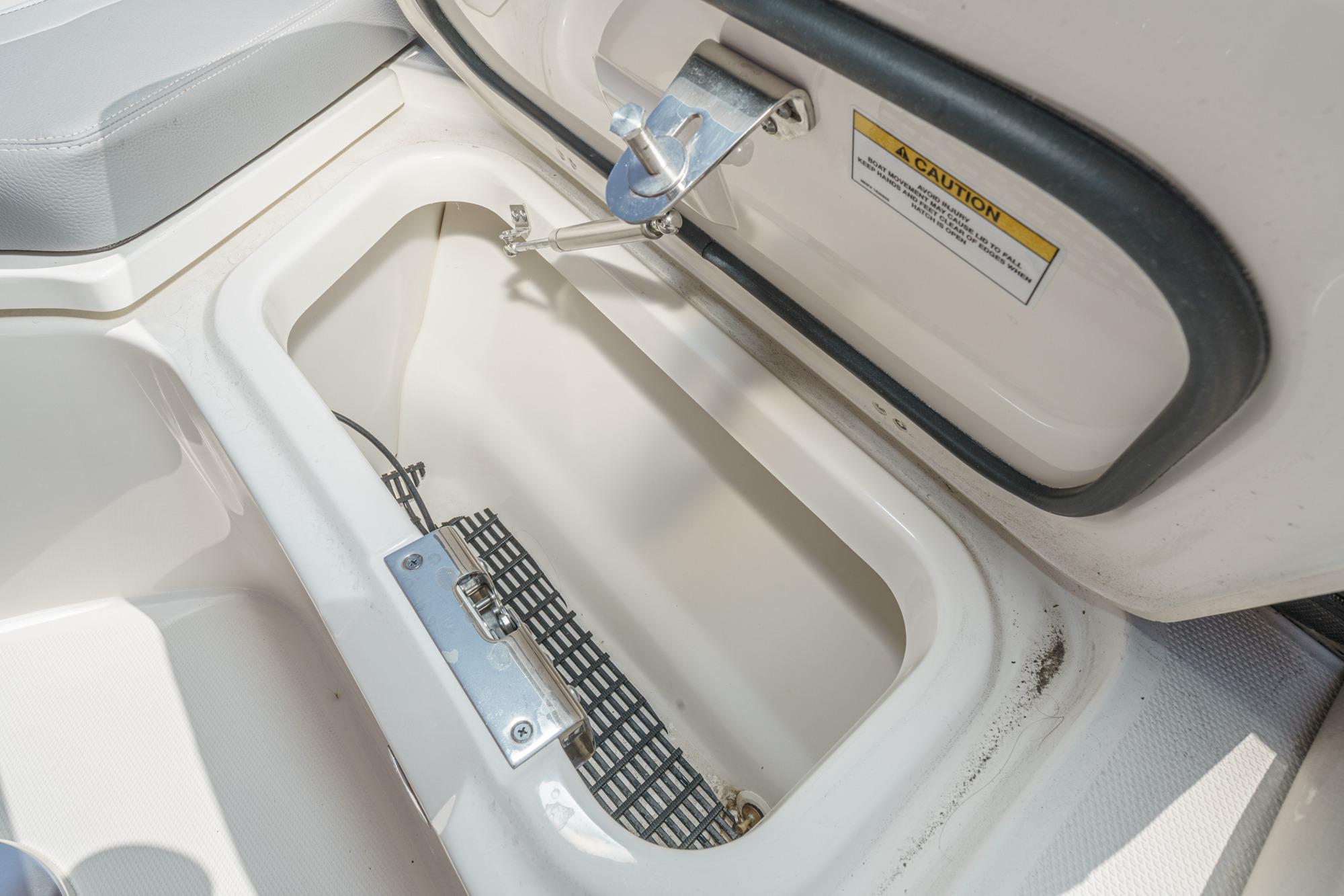 Storage compartment on 2024 Boston Whaler 380 Realm boat, featuring secure latch and caution label.