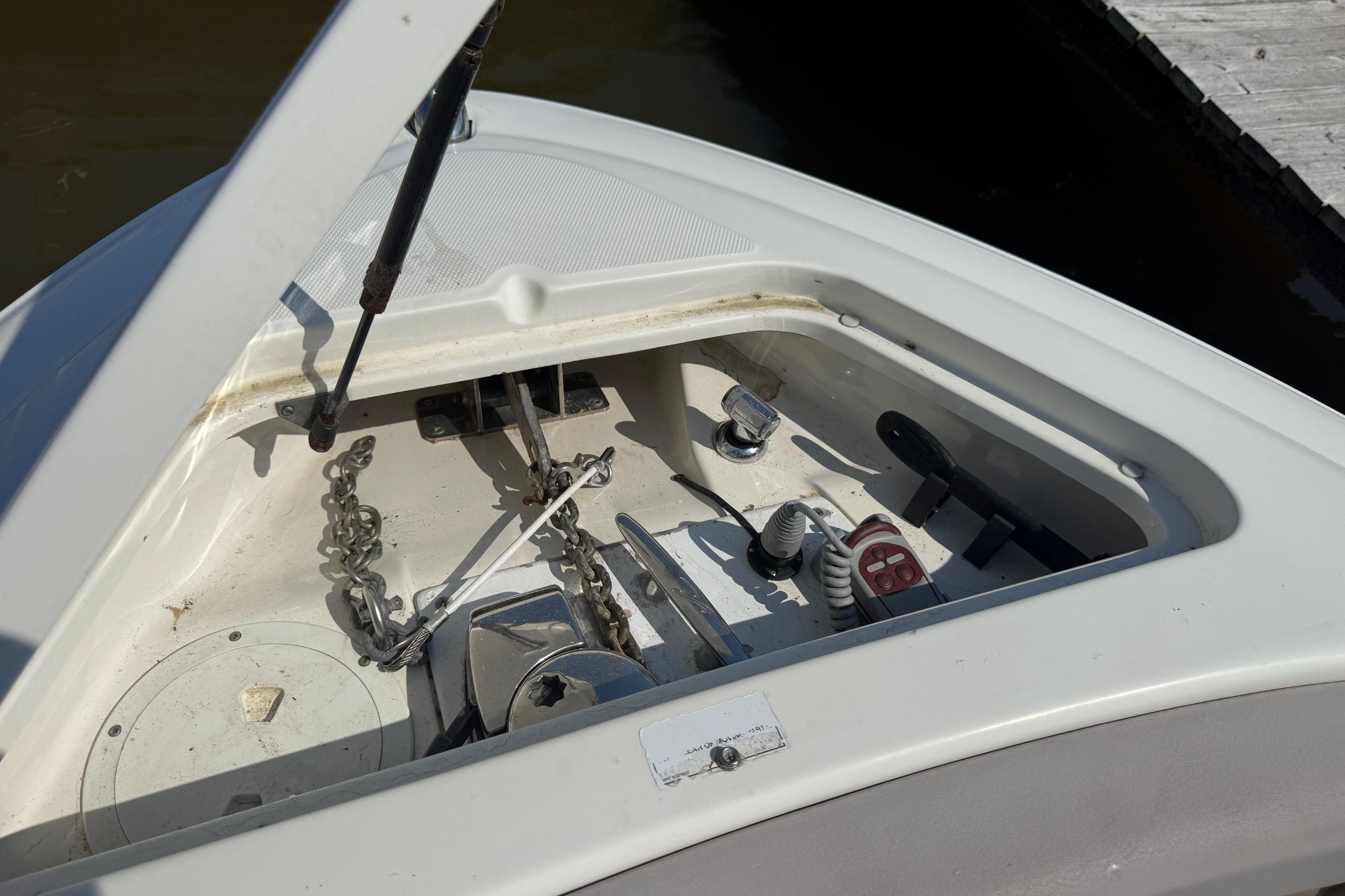 Open anchor compartment on a 2011 Sea Ray 270 SLX boat, showing chain and winch.