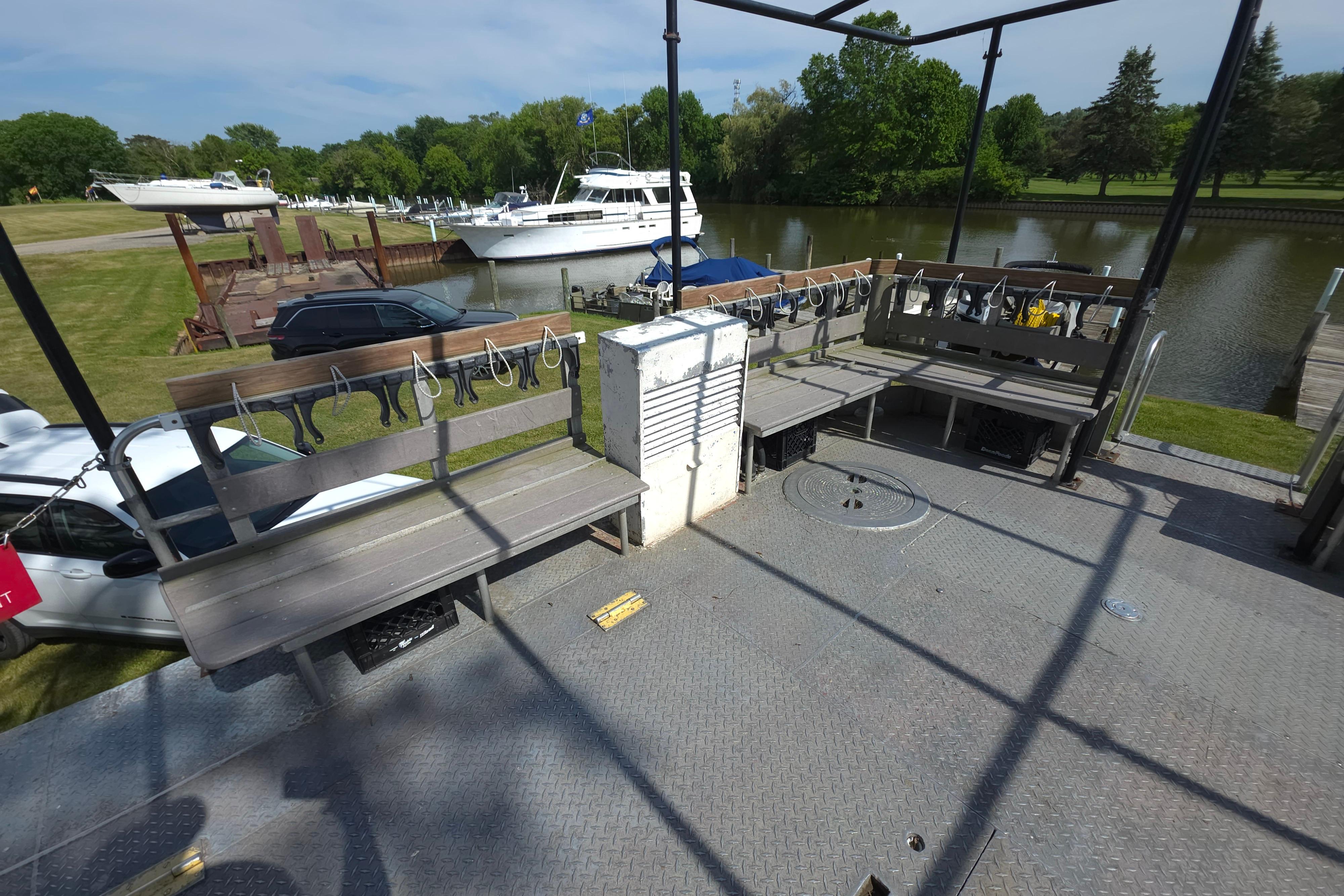 1974 Breaux's Bay Craft passenger boat deck with benches, docked near a serene river.