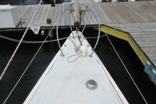 1974 Pearson 30 sailboat bow at dock, featuring deck fittings and mooring lines.
