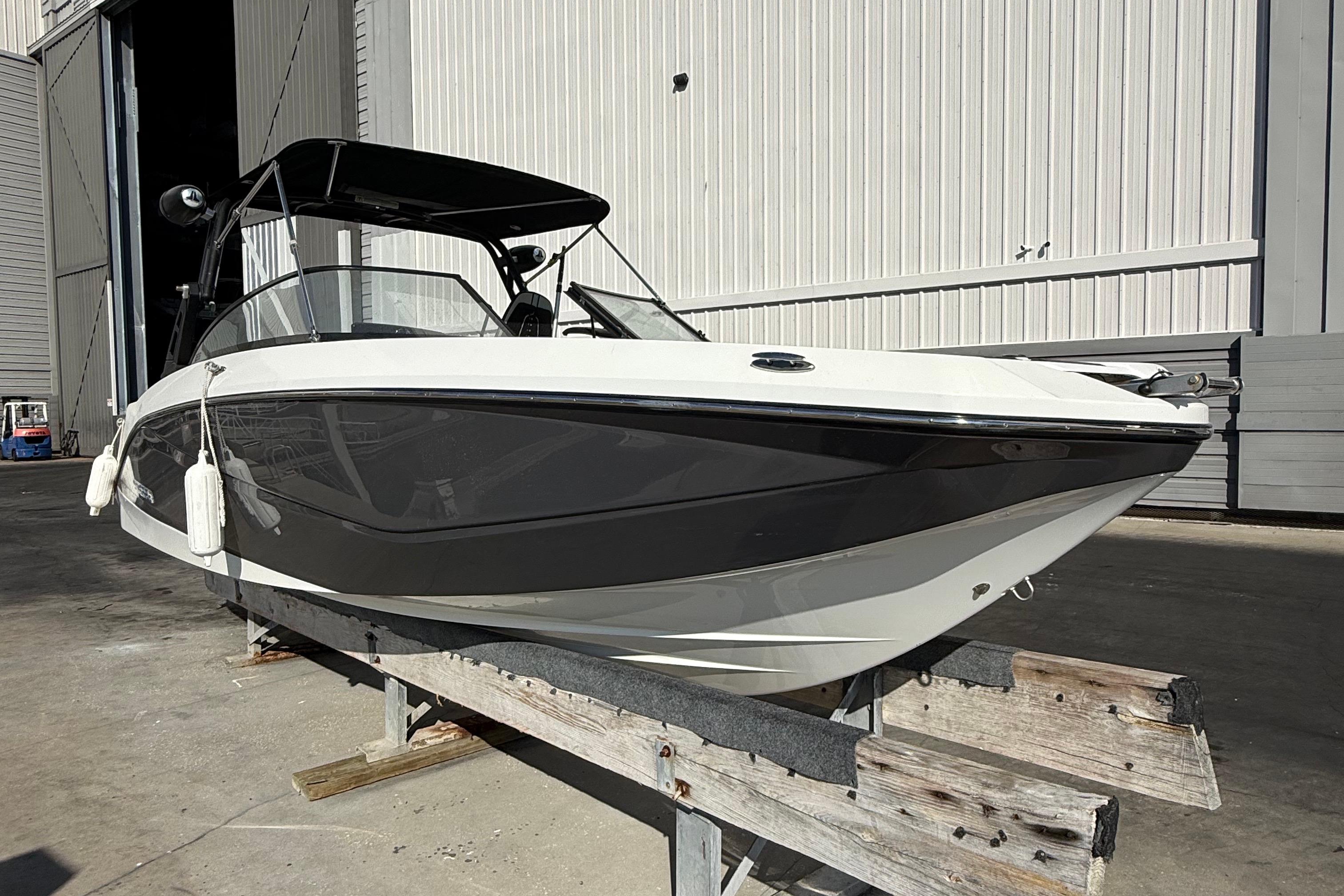 2021 Scarab 255 ID boat on a wooden stand outside a warehouse.