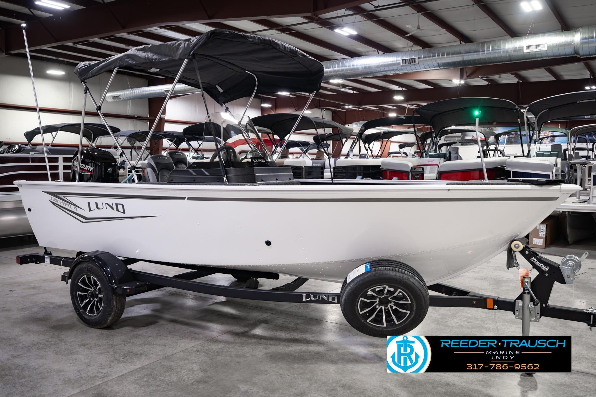 2026 Lund 1650 Rebel XL SS boat in showroom, side view with trailer.