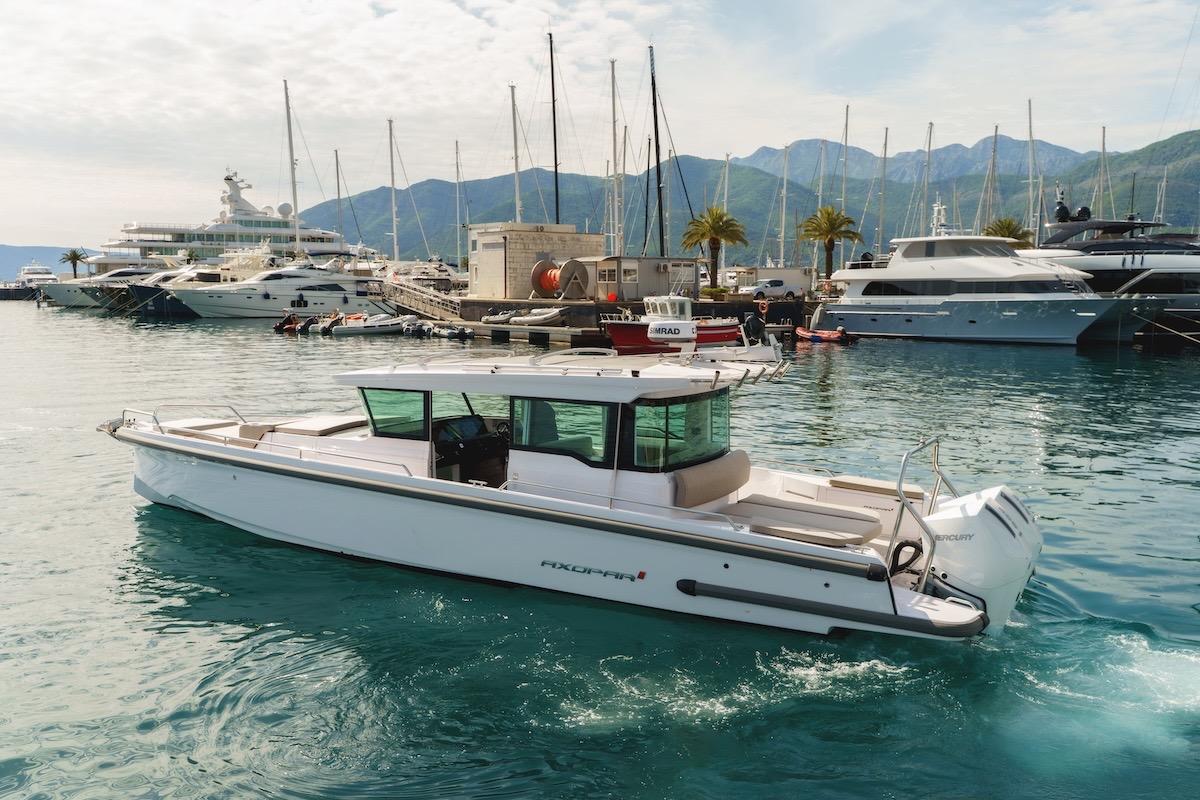 2024 Axopar 37 XC Cross Cabin boat docked in a scenic marina setting.
