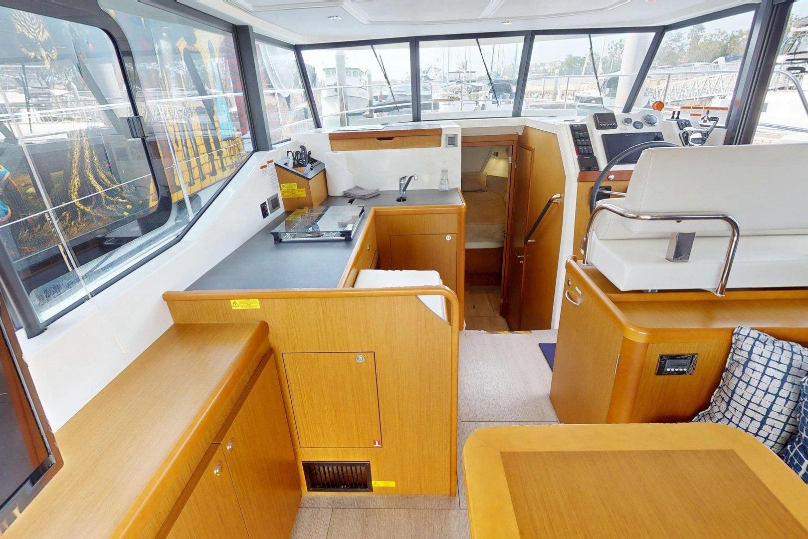 Interior of 2021 Beneteau Swift Trawler 35, featuring modern wood cabinetry and helm station.