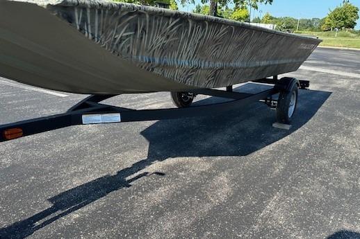 2026 Tracker Grizzly 1648 Utility boat on trailer in parking lot.