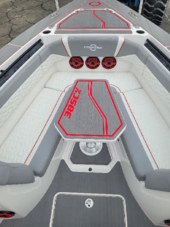2024 Fountain 38 SCX boat interior with red and gray accents, featuring seating and speakers.