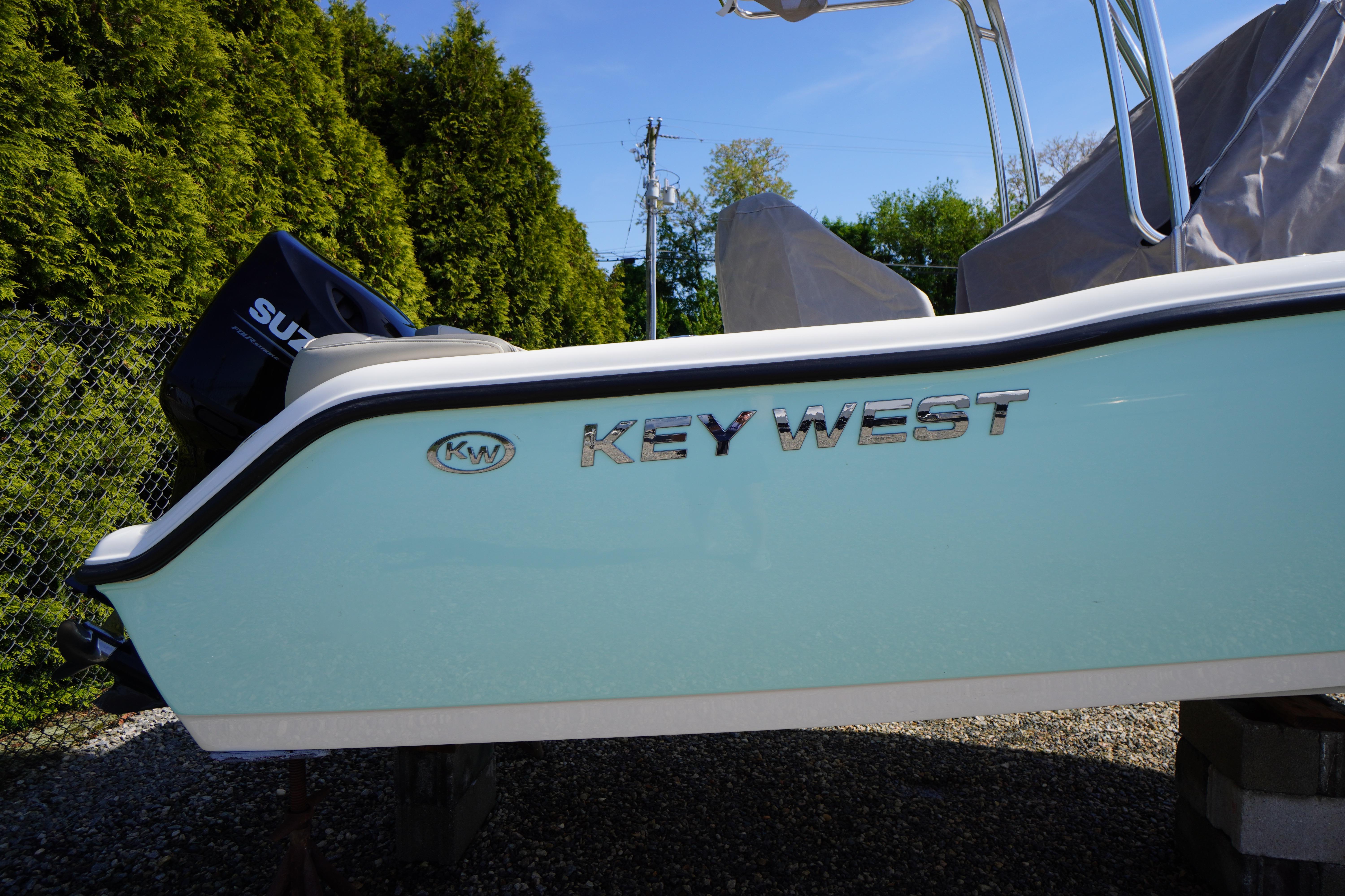 2025 Key West 203 FS boat side view with logo, parked outdoors.