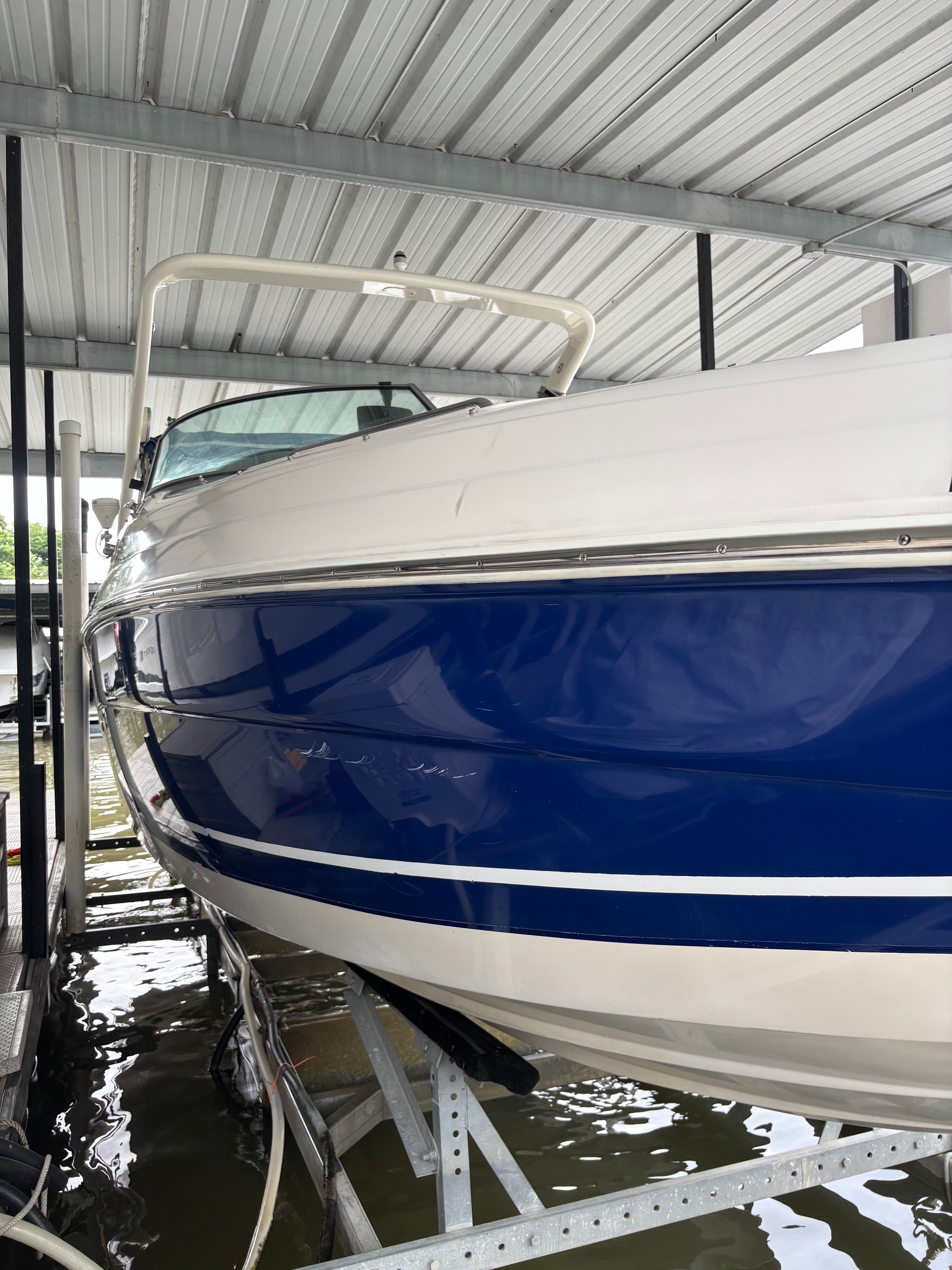 2006 Rinker 282 Captiva Bowrider in a covered dock, blue and white paint.