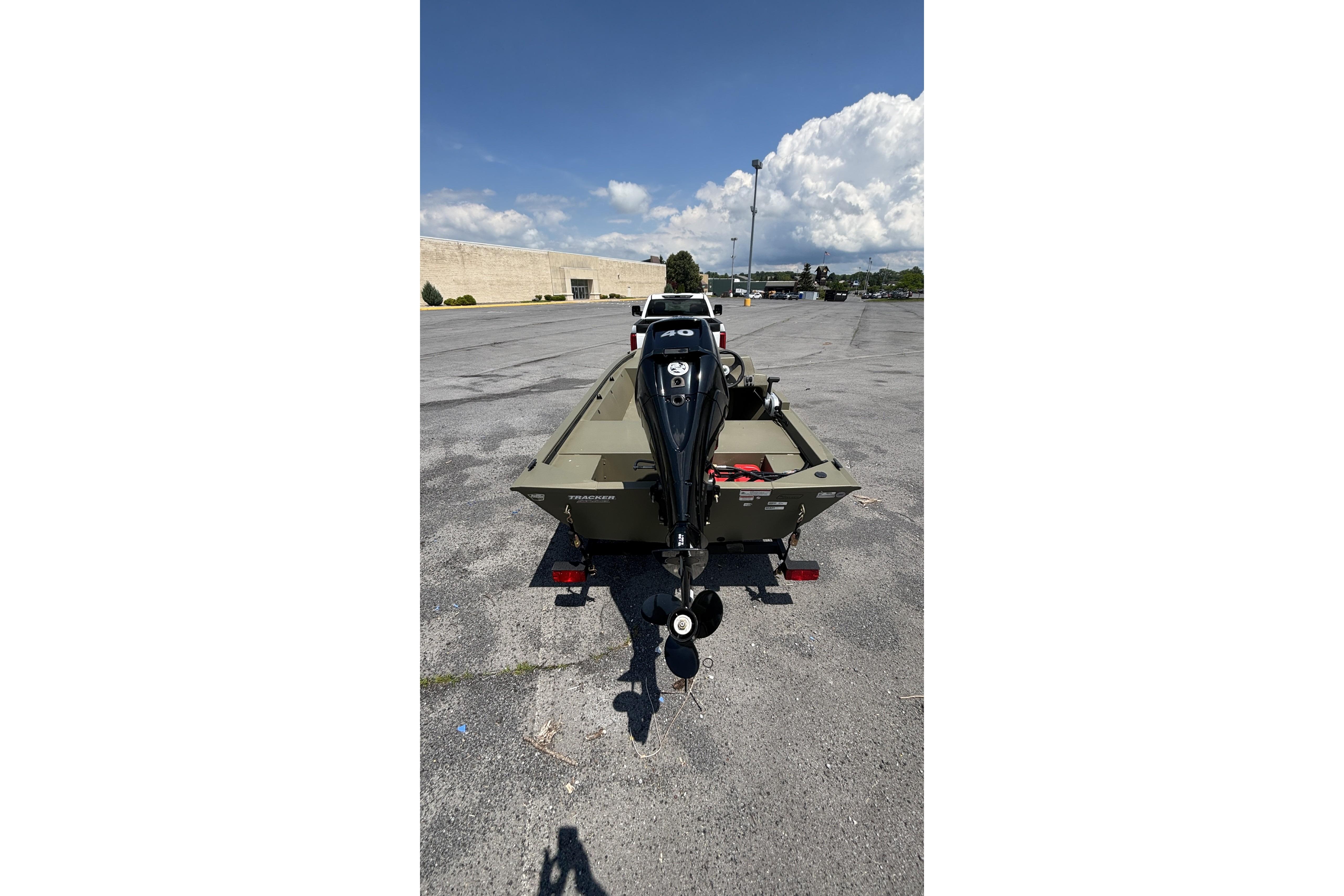 2026 Tracker Grizzly 1648 SC boat on trailer in parking lot, sunny day.