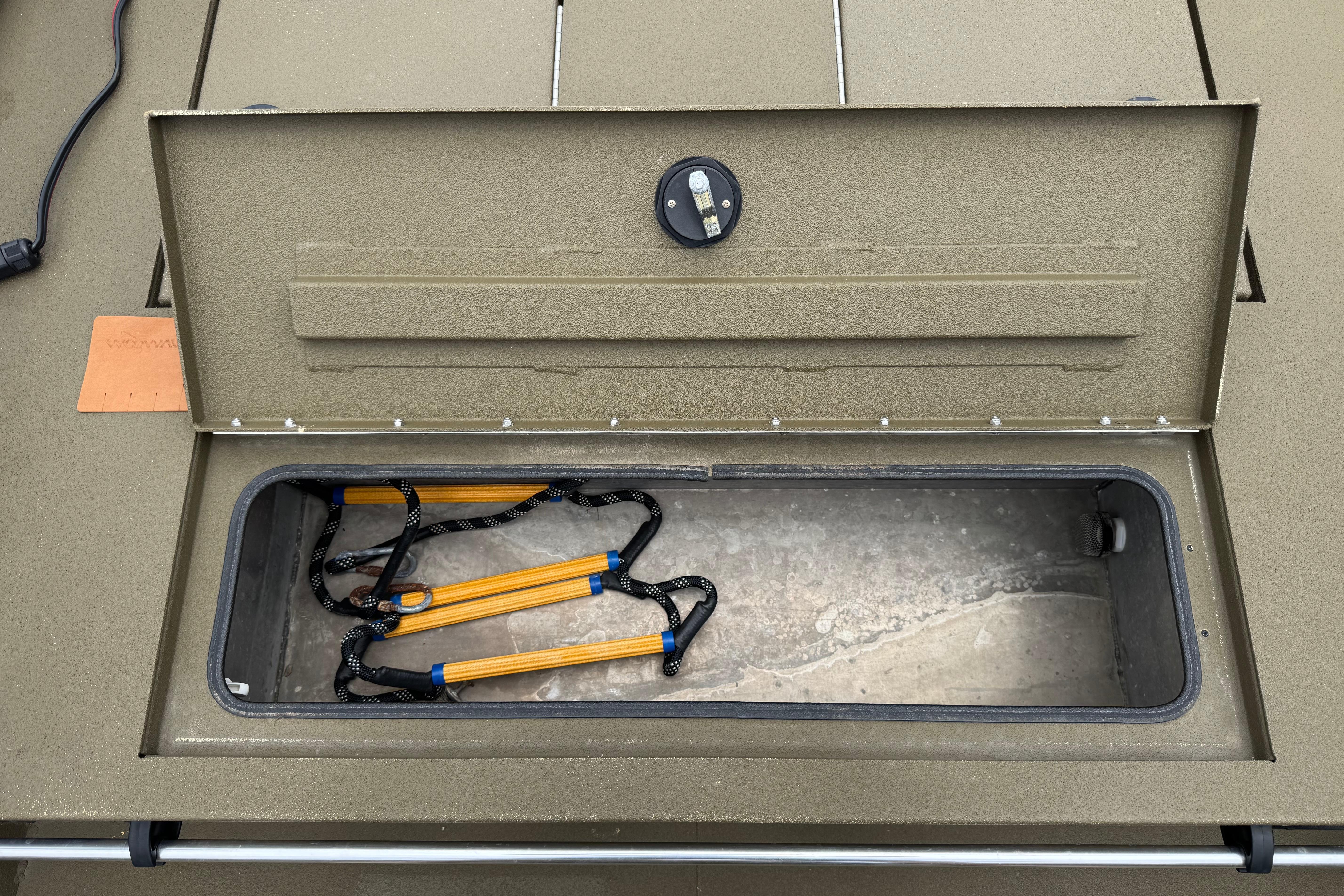 Open storage compartment in 2023 Avid 18 Rogue CC boat, featuring a rope ladder.