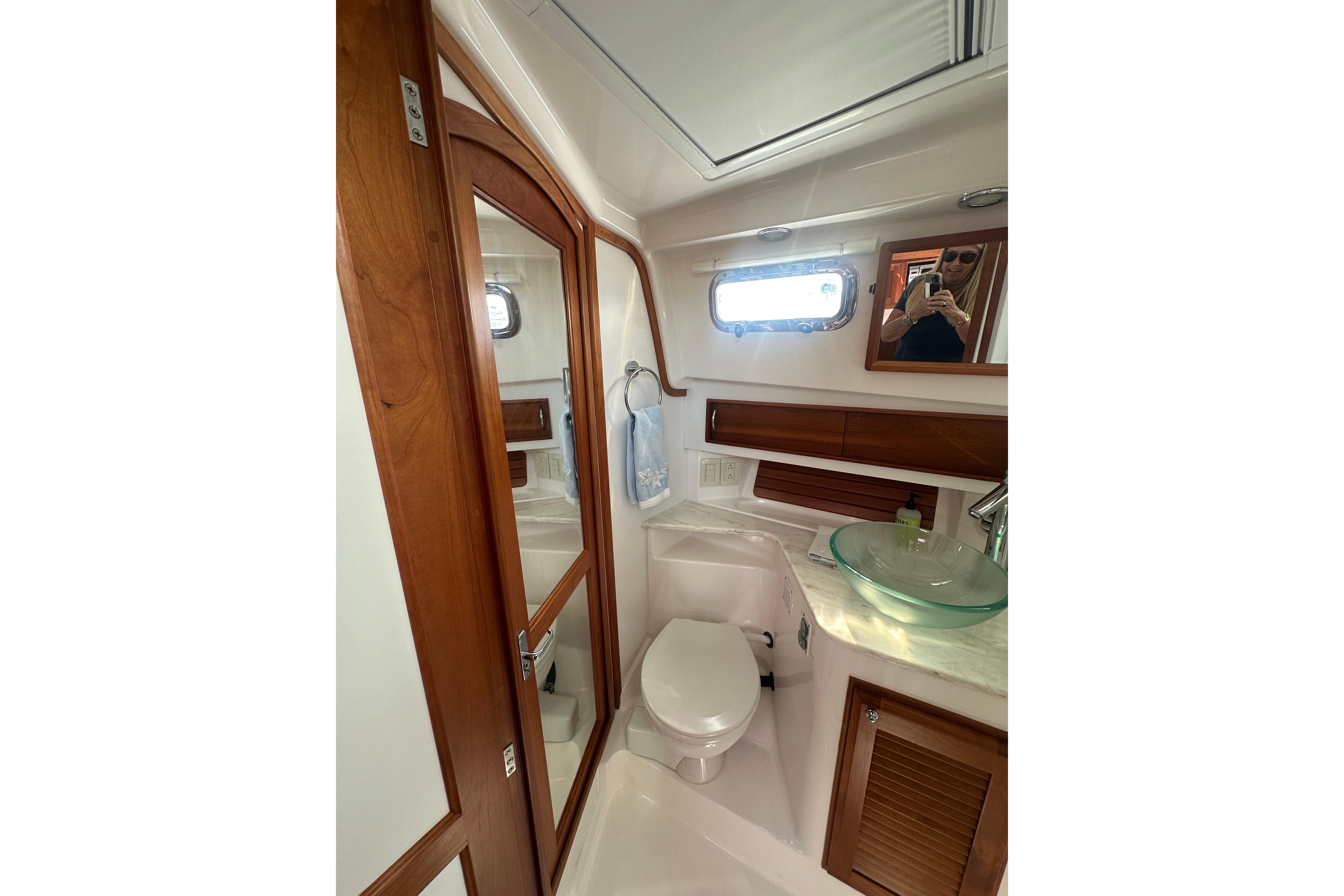 2013 Sabre 38 Salon Express bathroom with wooden accents and glass sink.