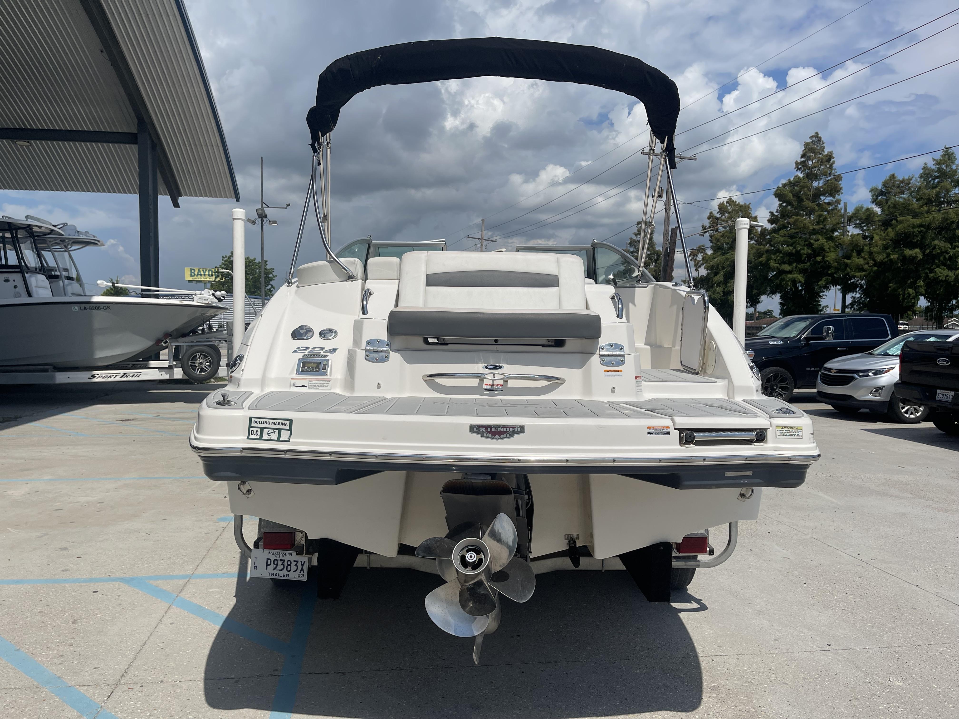 2014 Chaparral Sunesta 224 boat, rear view, parked outdoors under cloudy sky.