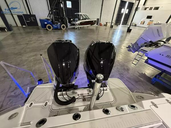 2025 Blackfin 272CC boat with dual engines in a spacious indoor marina.