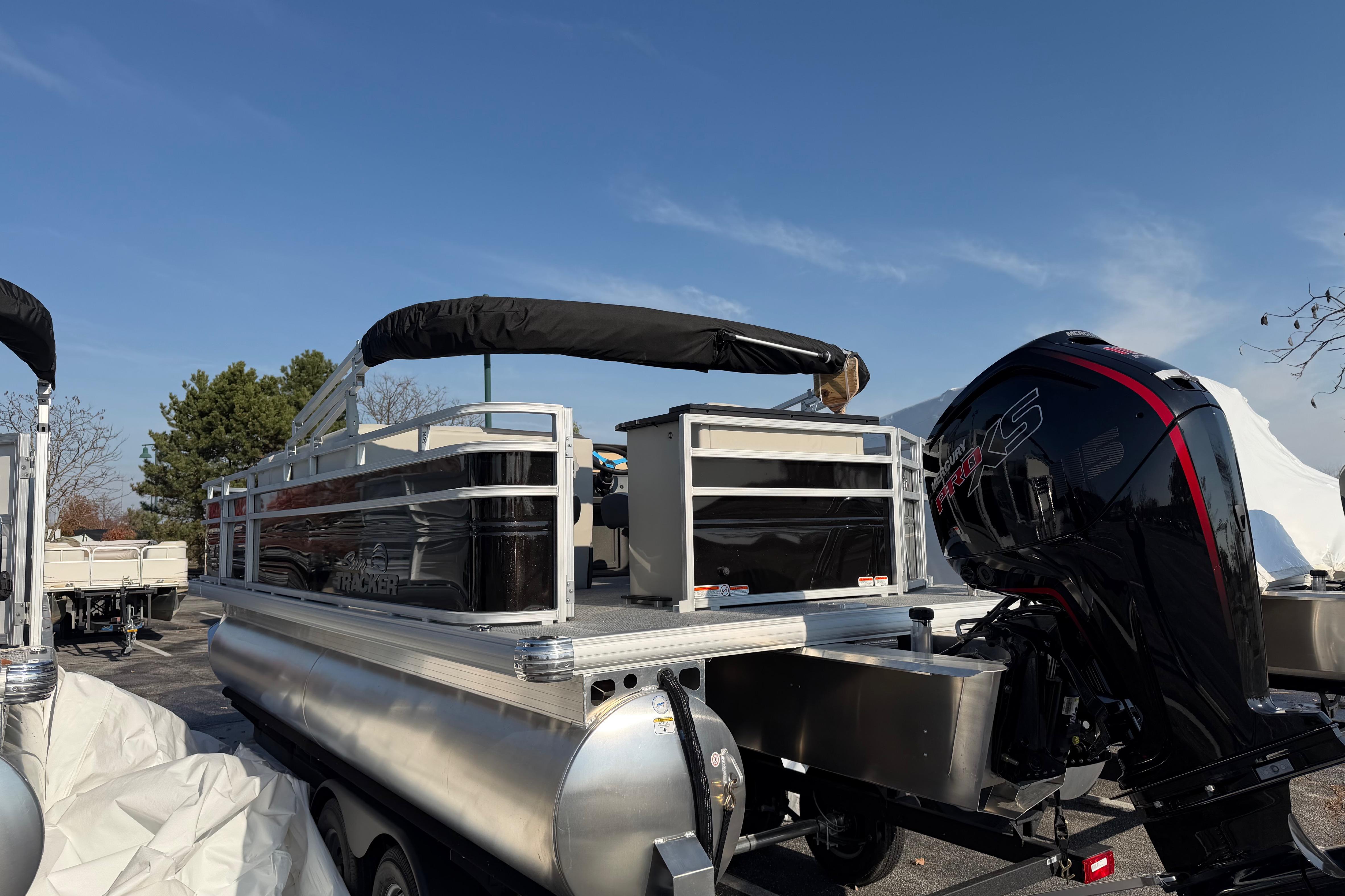 2026 Sun Tracker Fishin' Barge 20 DLX pontoon boat with powerful outboard motor.