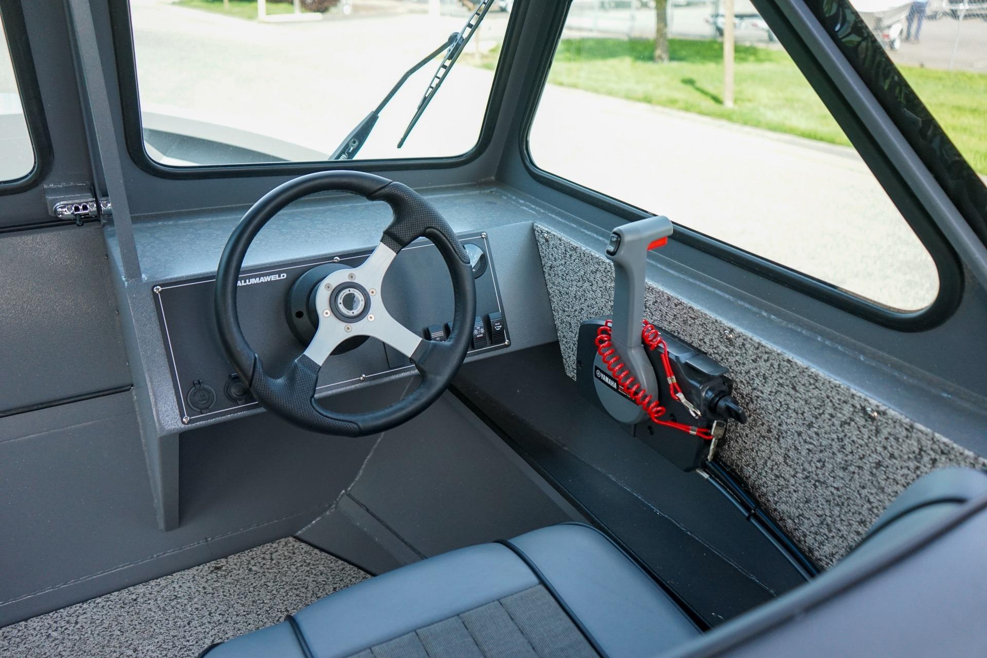 Interior of 2026 Alumaweld Talon 18 boat, featuring steering wheel and control panel.