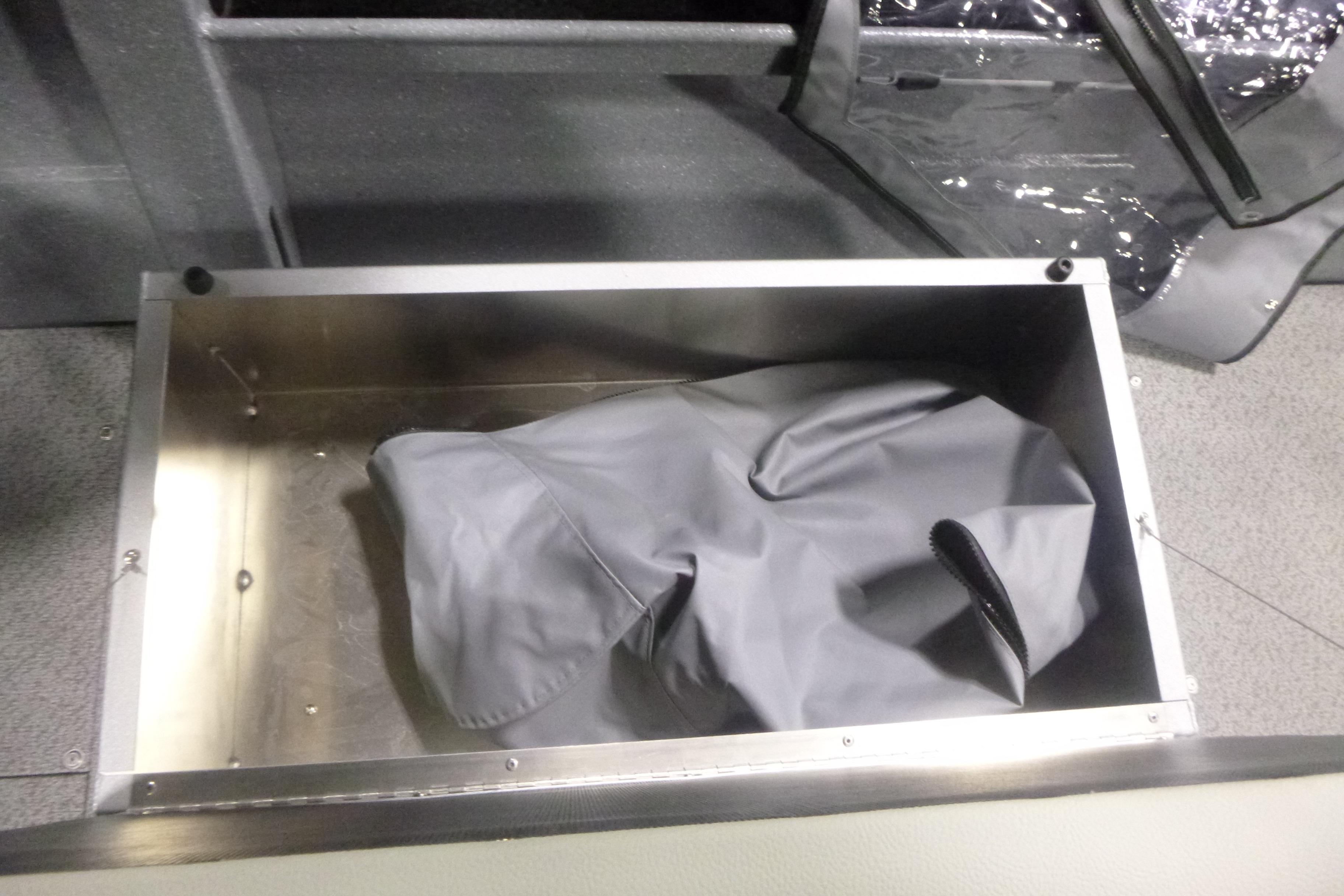 Storage compartment in KingFisher 2025 Falcon boat, featuring a gray cover.