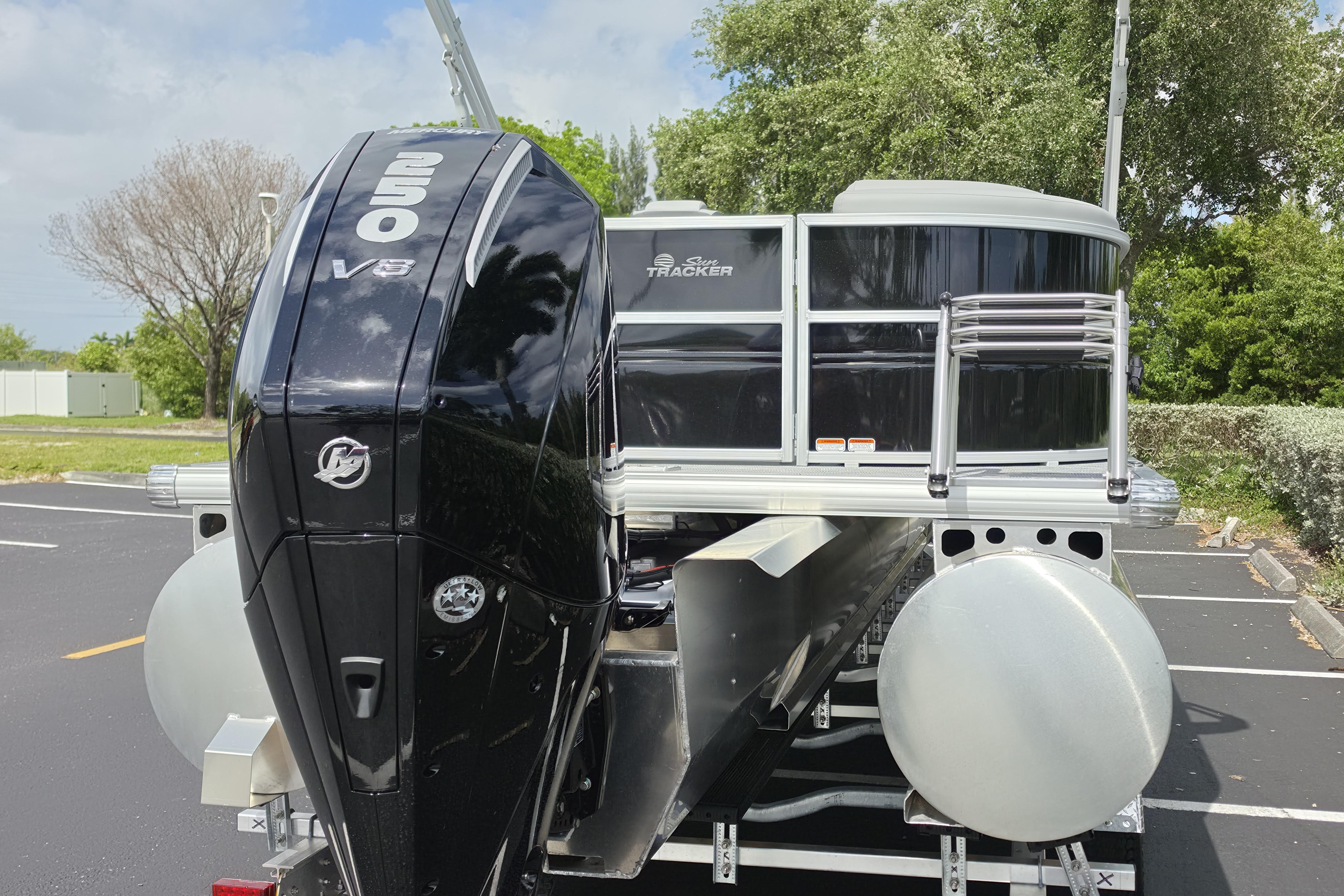 2026 Sun Tracker Party Barge 24 XP3 with powerful 250 V8 engine in a parking lot.