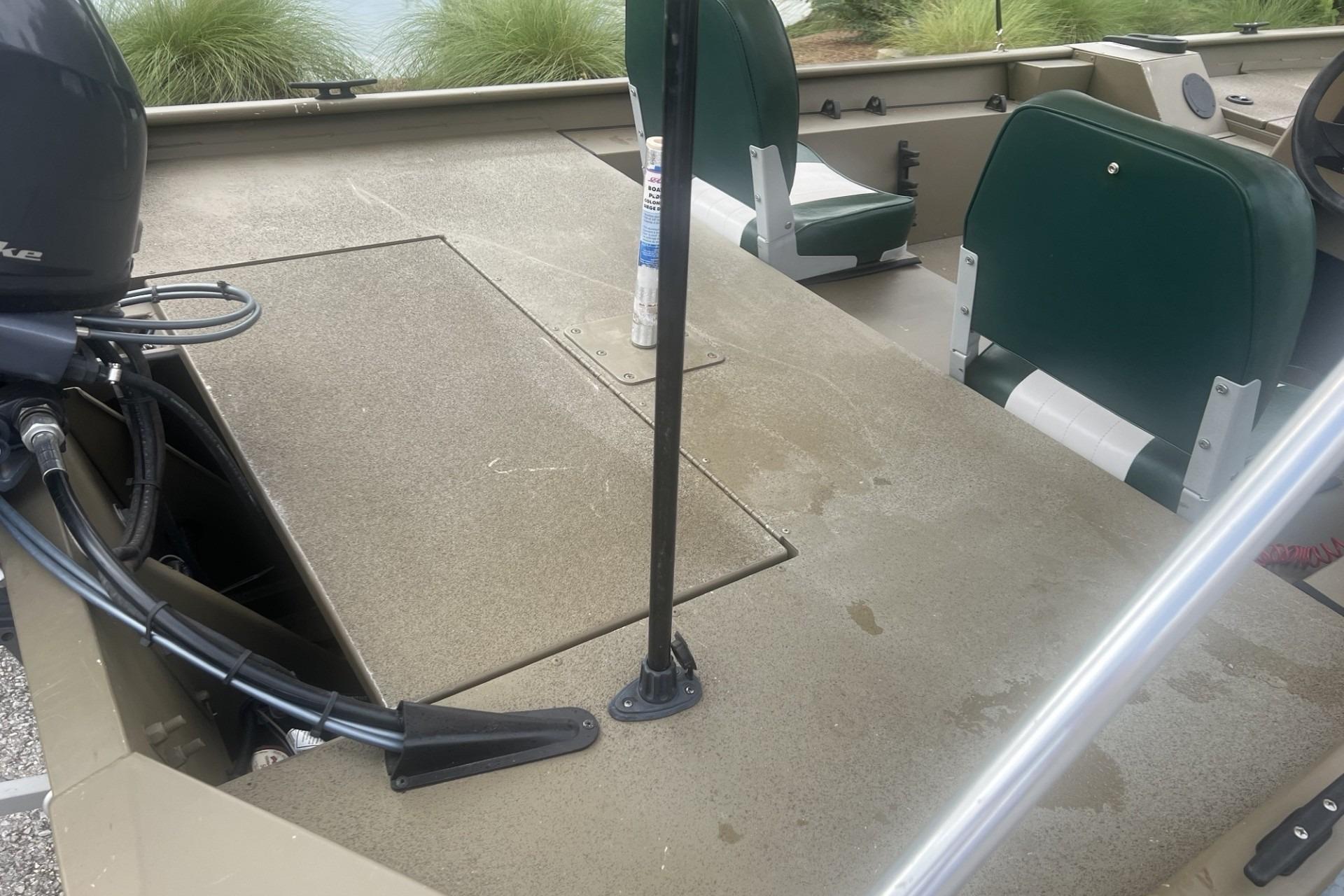 2016 G3 1756 SC boat interior with green seats and motor, showcasing deck and steering area.