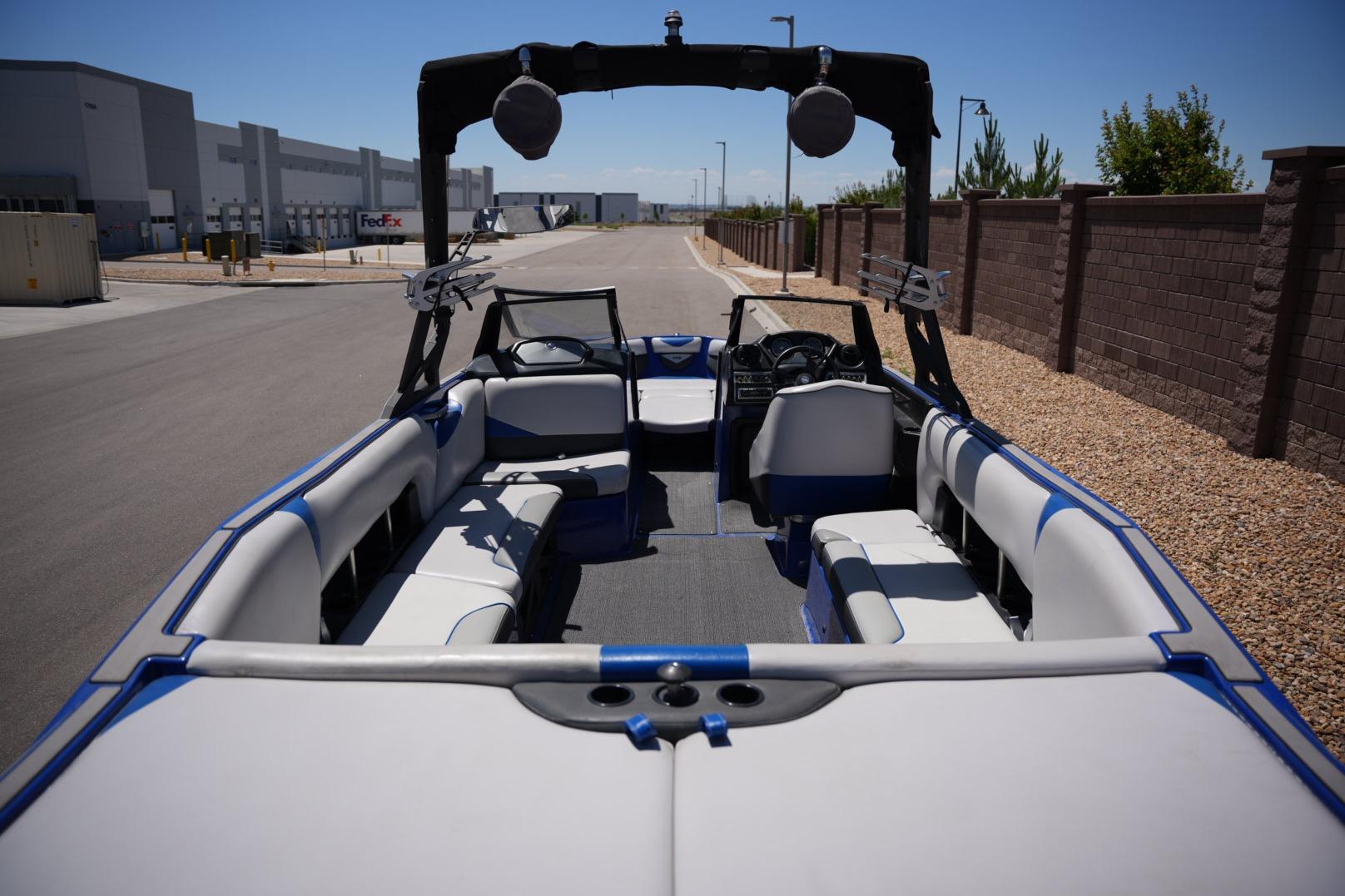2015 Axis A24 boat interior with blue accents, parked near industrial buildings.