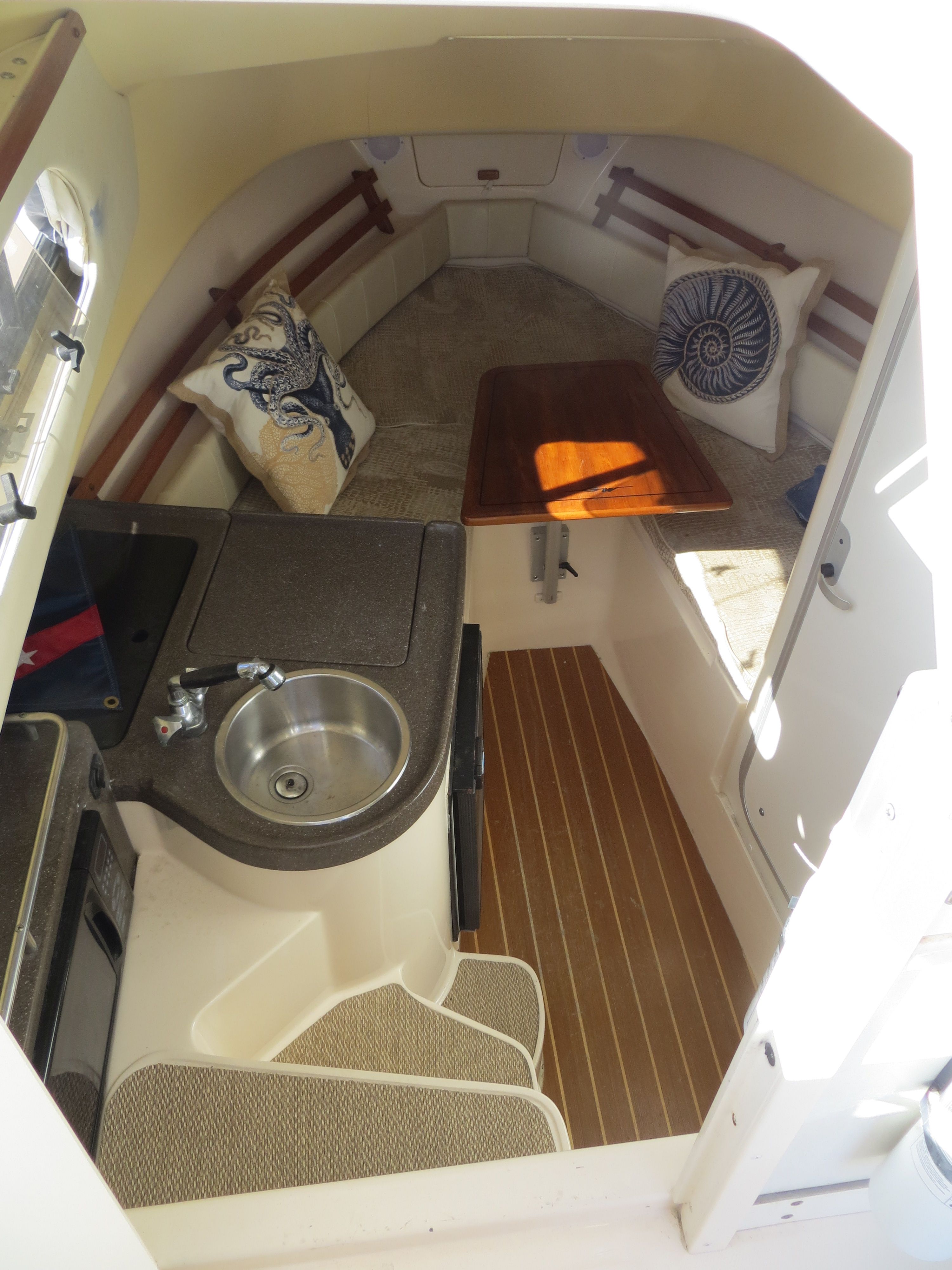 Interior of Grady-White Sailfish 282 with seating area and small kitchenette.