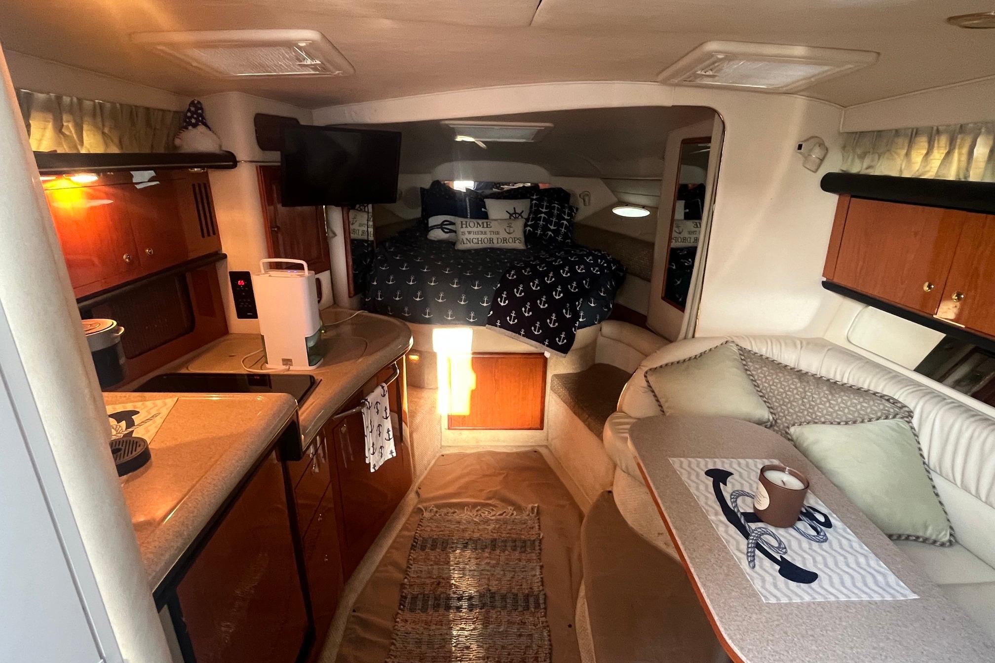 Interior of 2001 Sea Ray 340 Sundancer yacht with cozy seating and kitchenette.