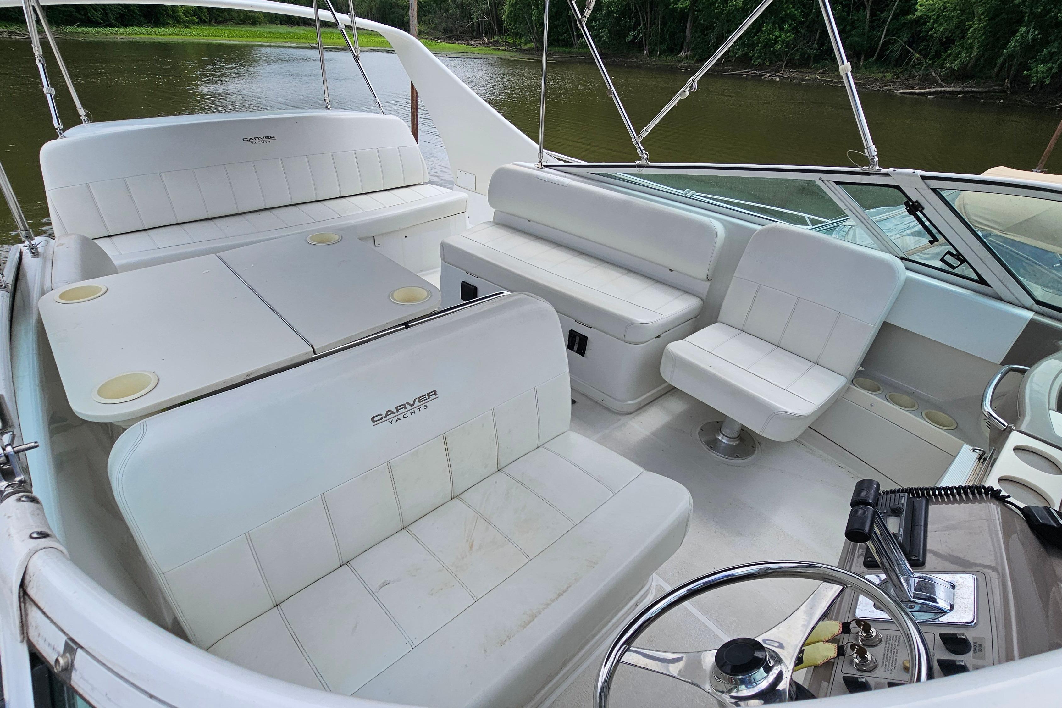 1999 Carver 350 Mariner yacht interior with white seating and steering wheel.