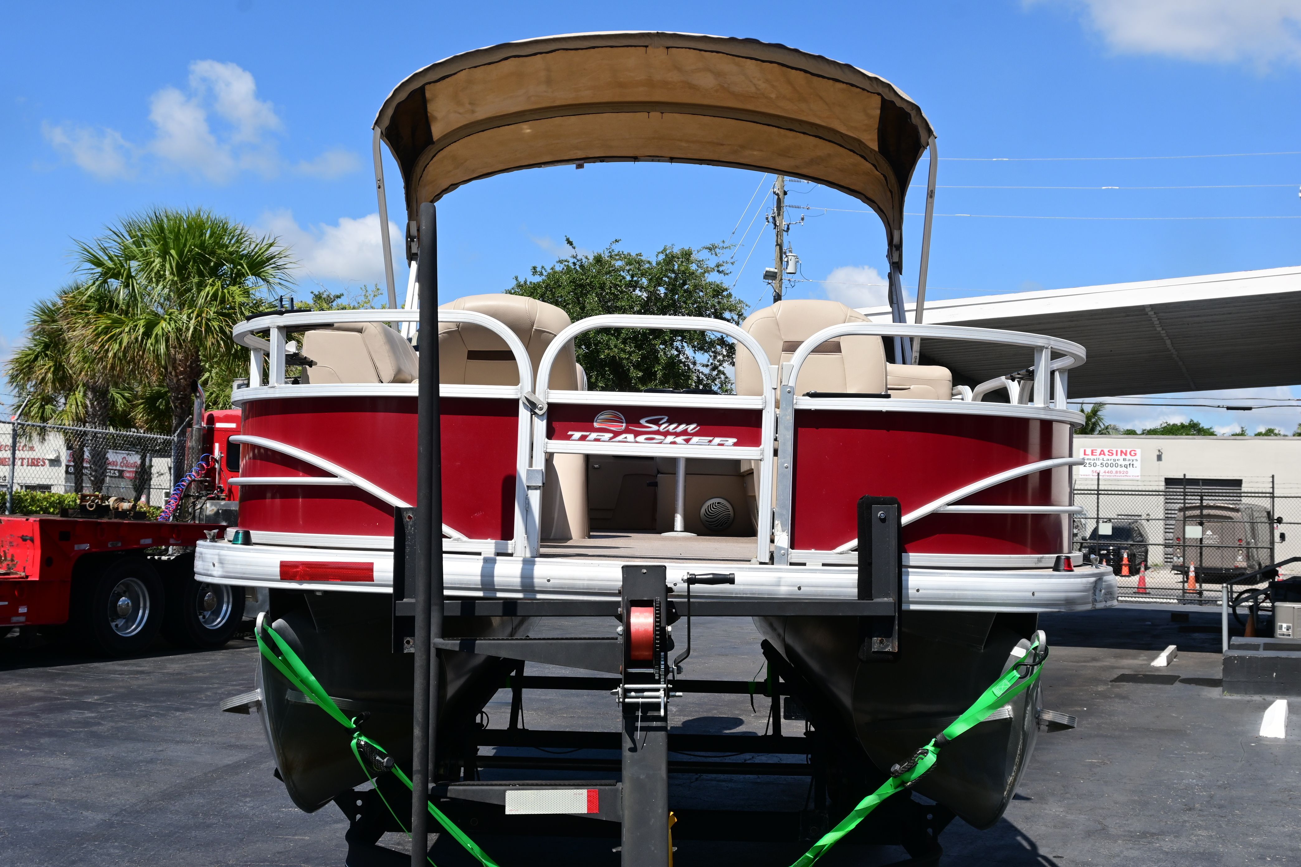 2019 Sun Tracker FISHI pontoon boat on trailer, red design.