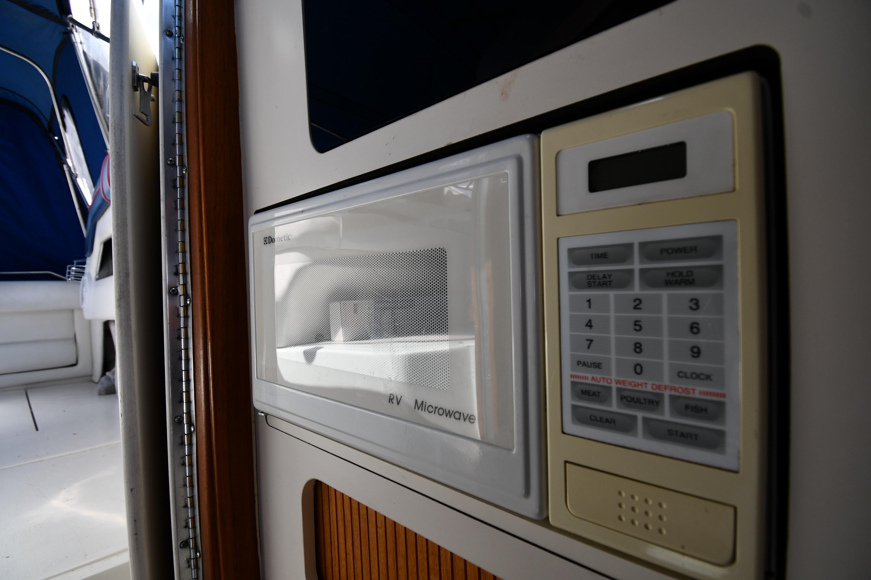 Microwave inside 1993 Sea Ray 300 Sundancer boat, featuring control panel and interior view.