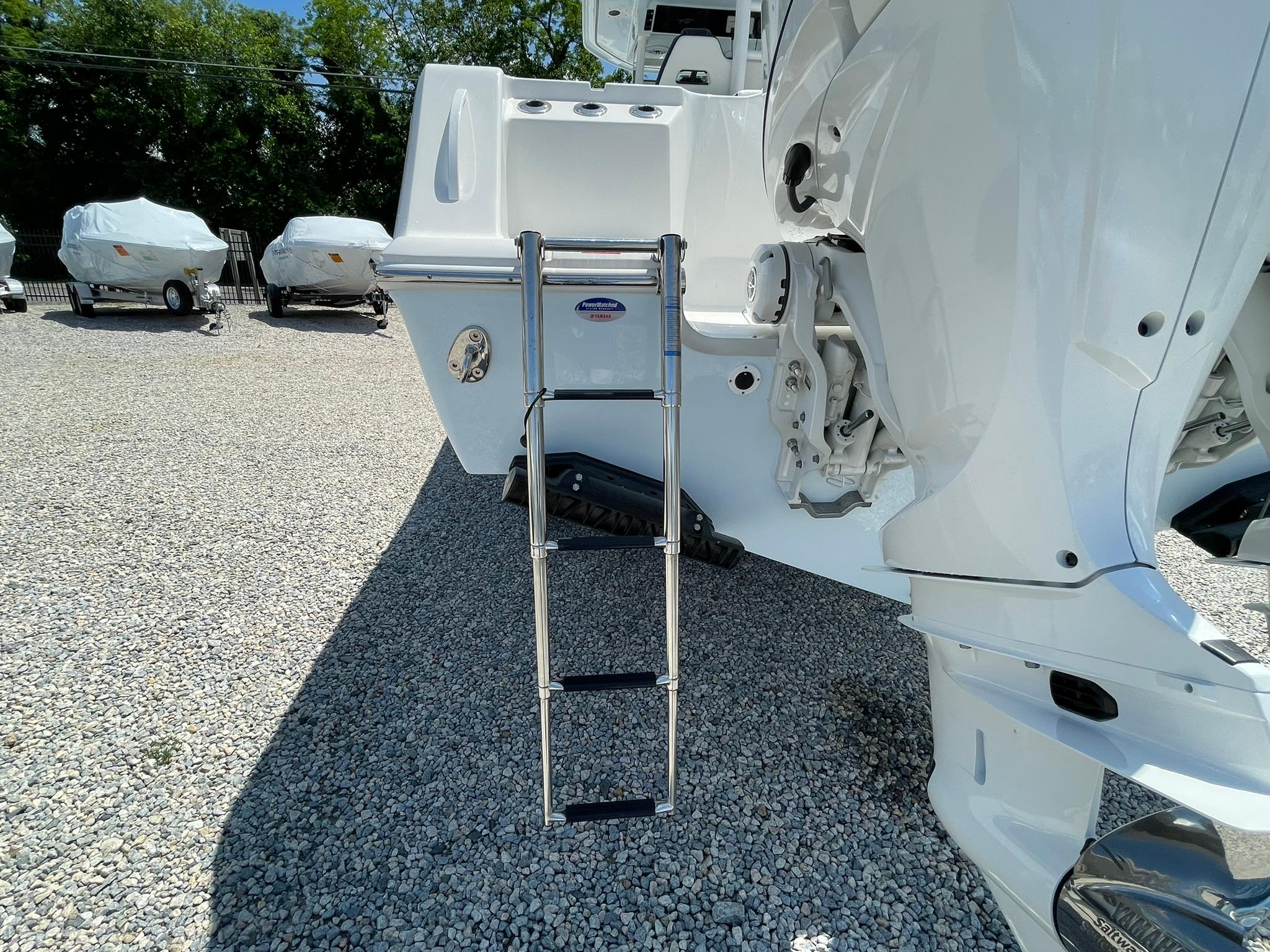 2026 Tidewater 302 CC Adventure boat with ladder on gravel lot.