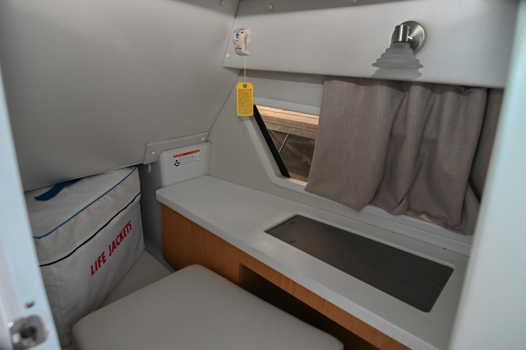 Interior cabin of 2014 Four Winns H290 boat with life jackets and window.