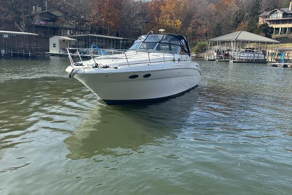 2004 Sea Ray 380 Sundancer boat on calm lake near docks.