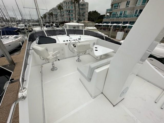 Flybridge of 2025 Bracewell 41 yacht with helm, seating, and table in marina setting.